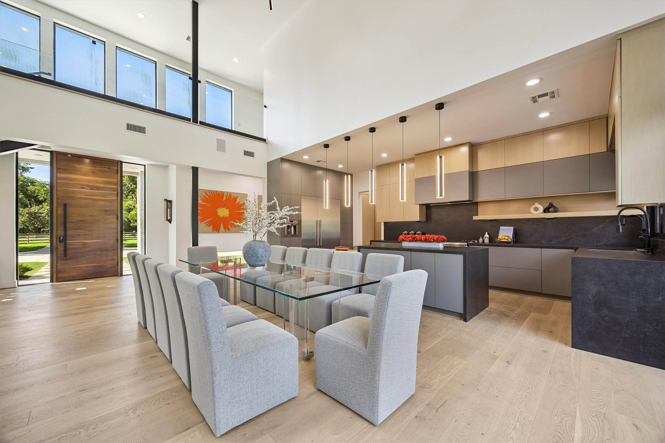 An elegant dining setting flows naturally into the contemporary kitchen and grand living room, creating an inviting atmosphere for everything from intimate dinners to memorable celebrations.