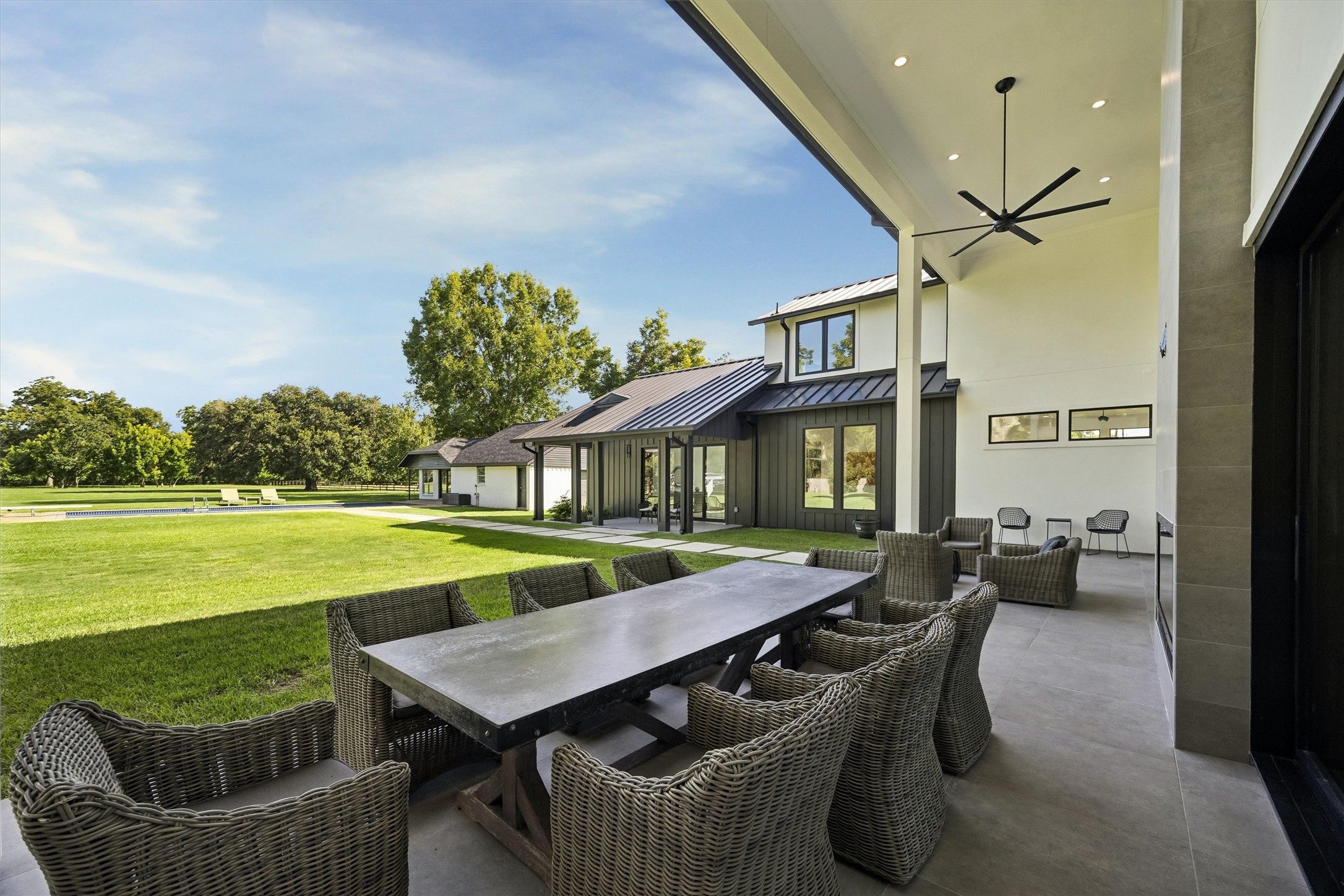 An elegant covered dining terrace offers an extraordinary setting for memorable gatherings, with sweeping views of the manicured grounds and seamless access to the home's outdoor living spaces.