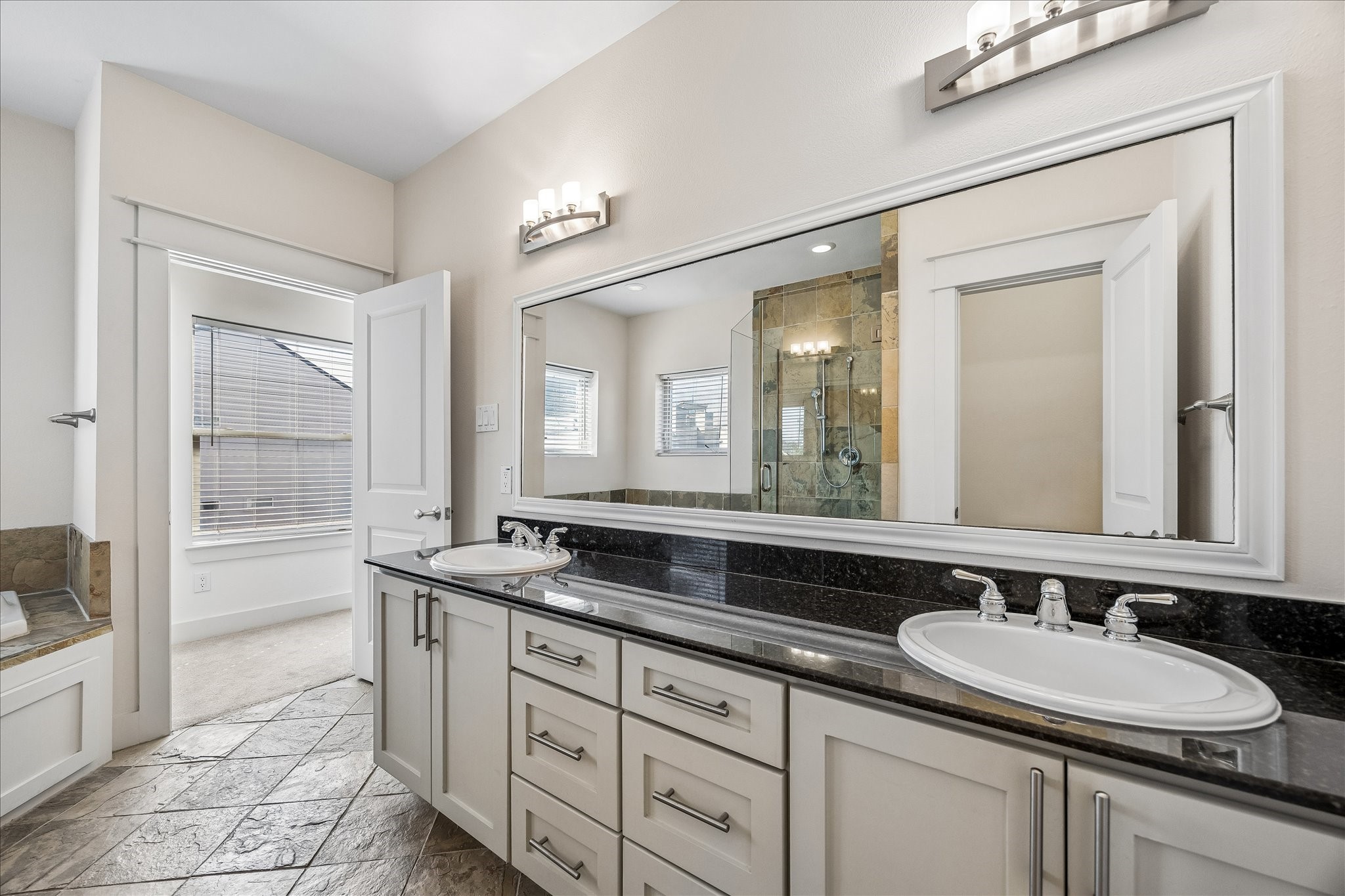 The primary bathroom features granite countertops and double sinks
