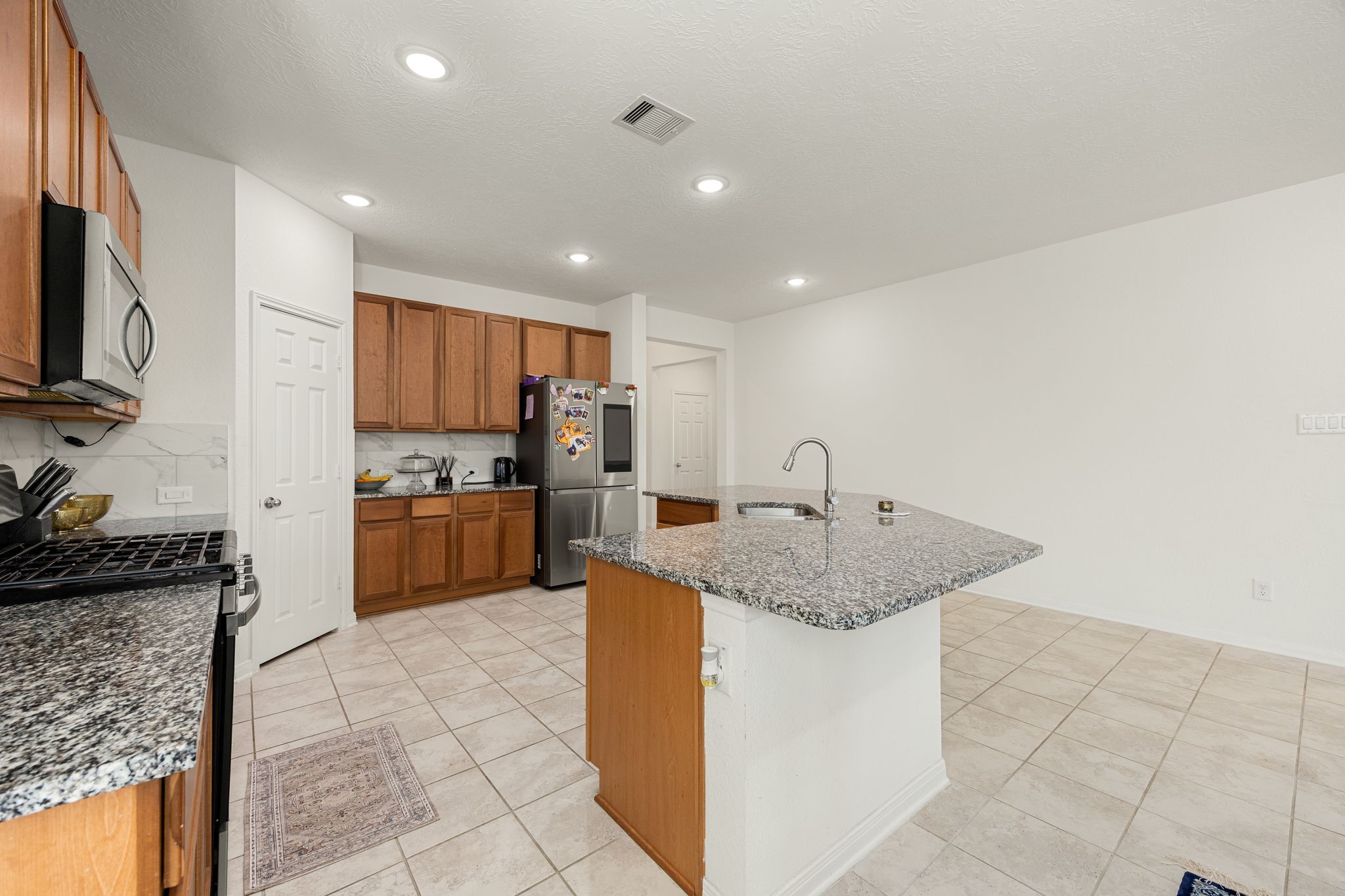 Designed for social living, the large kitchen island doubles as an inviting breakfast bar where family and guests can pull up a stool and chat. This commanding central meeting place bridges the cooking zone with the rest of the open floor plan, making entertaining natural and effortless.