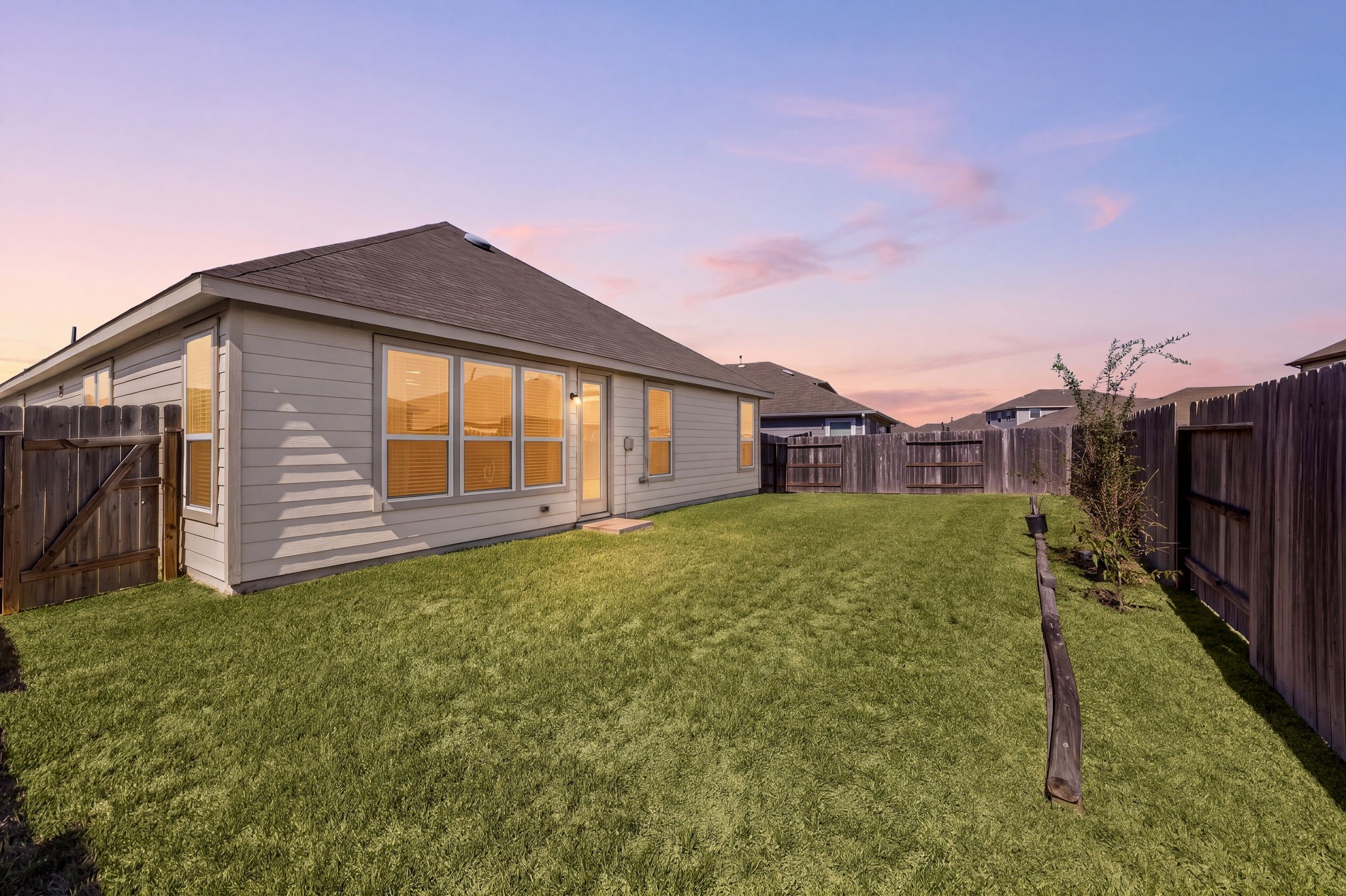 Step outside to a fully fenced backyard that offers an abundance of green space for outdoor recreation, gardening, or furry friends. The property features a clean, level lawn wrapped in a privacy wooden fence, offering a peaceful and secure setting with endless potential to design your dream outdoor oasis.