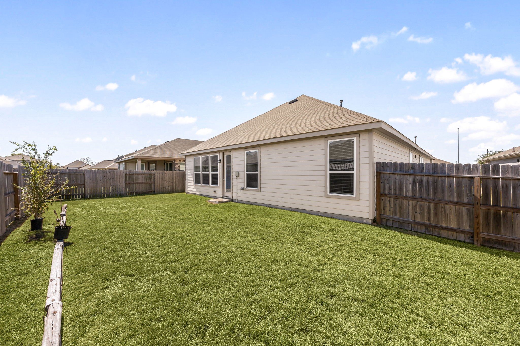 Enjoy maximum versatility in this expansive outdoor area. The clear, flat footprint runs deep along both sides of the home, offering an easy layout for added storage sheds, customized garden beds, or a sweeping concrete patio expansion directly off the back doorway.