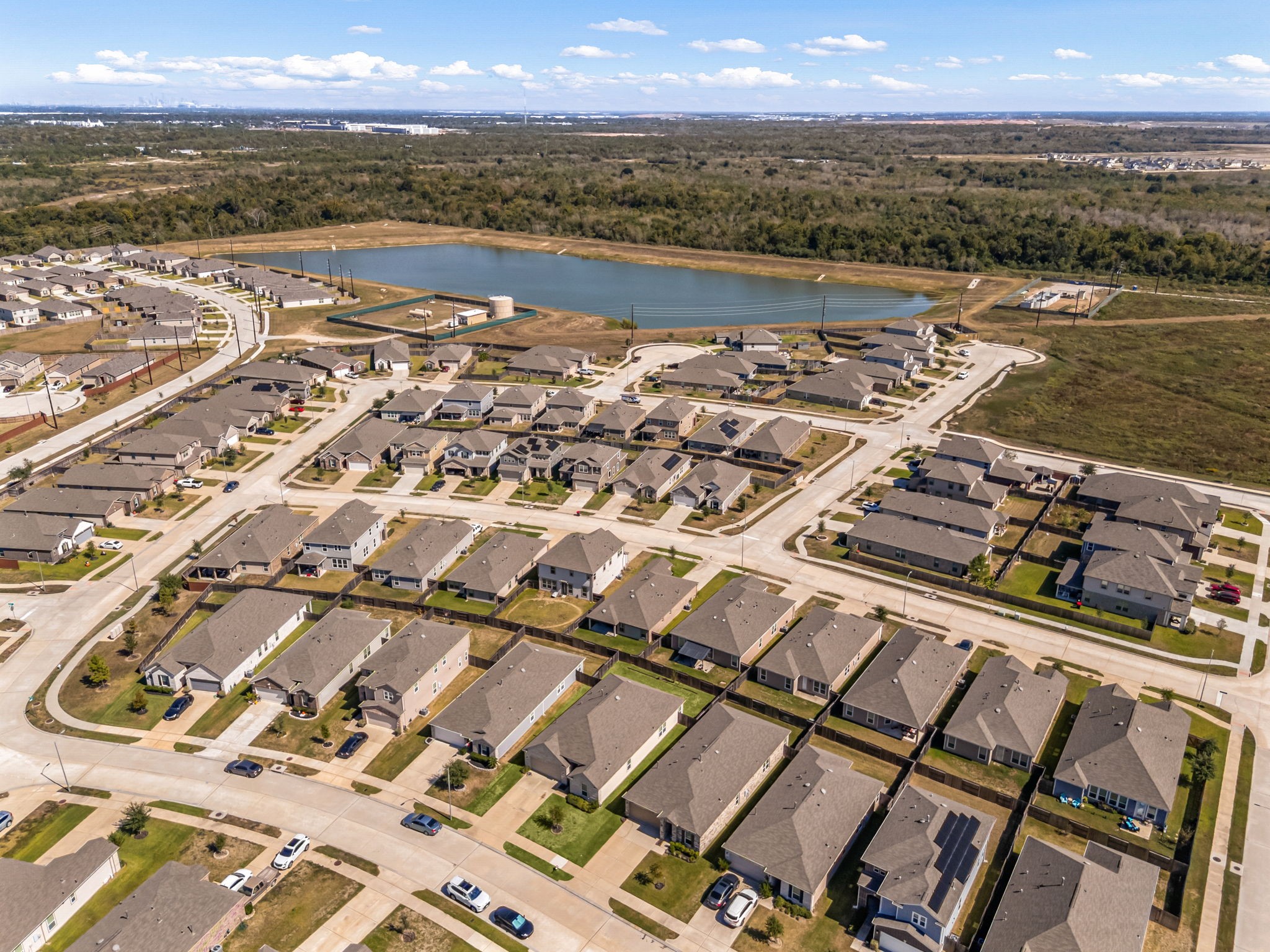 Welcome to life at Olympia Falls in Fresno! This bird's-eye perspective highlights the master-planned community's extensive green space and sparkling detention lake. Designed for active and social lifestyles, the neighborhood features excellent amenities like a central park, walking trails, and a dedicated children's play area, all just moments away from your front doo