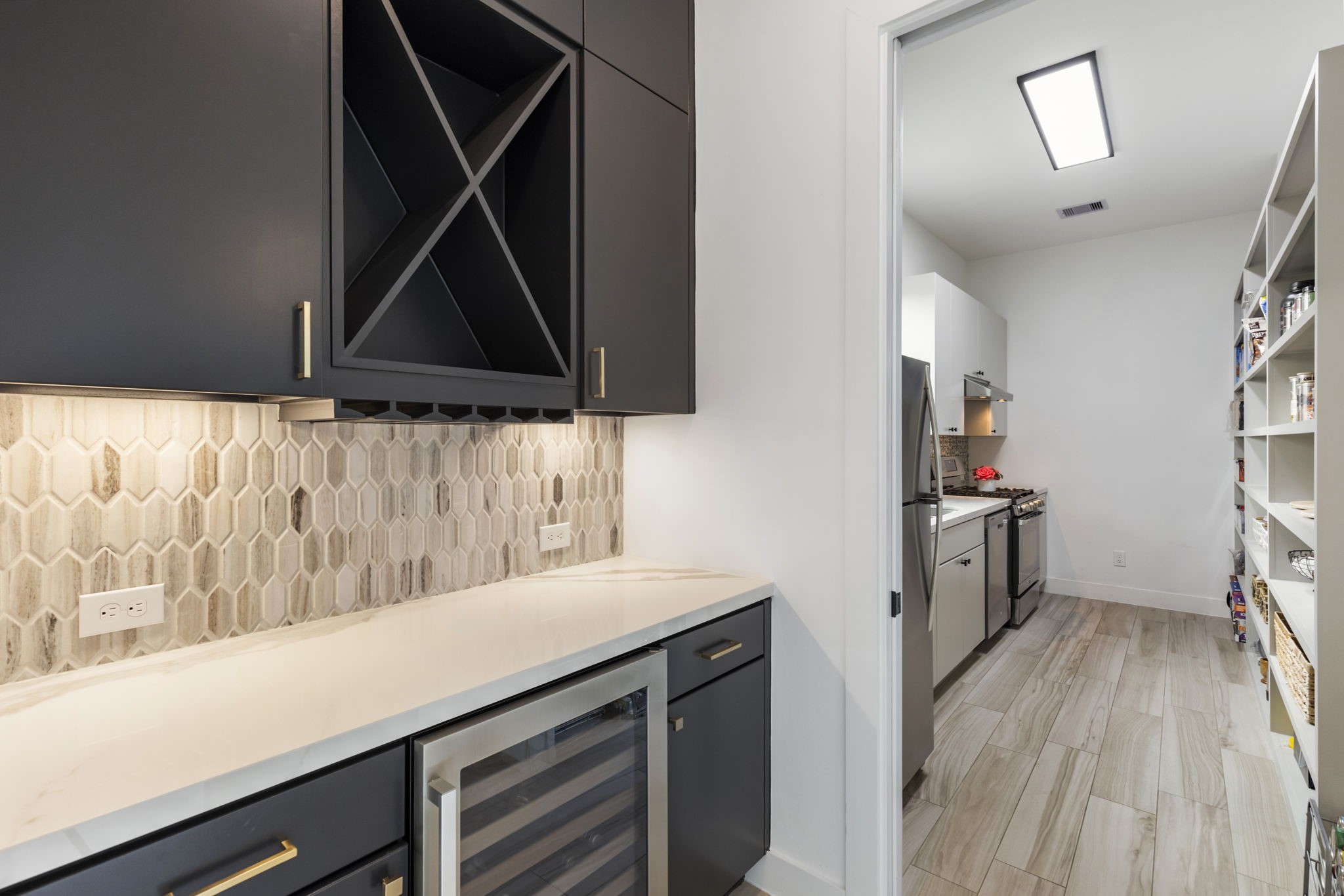 beverage cooler with extra cabinet storage that leads into the pantry.