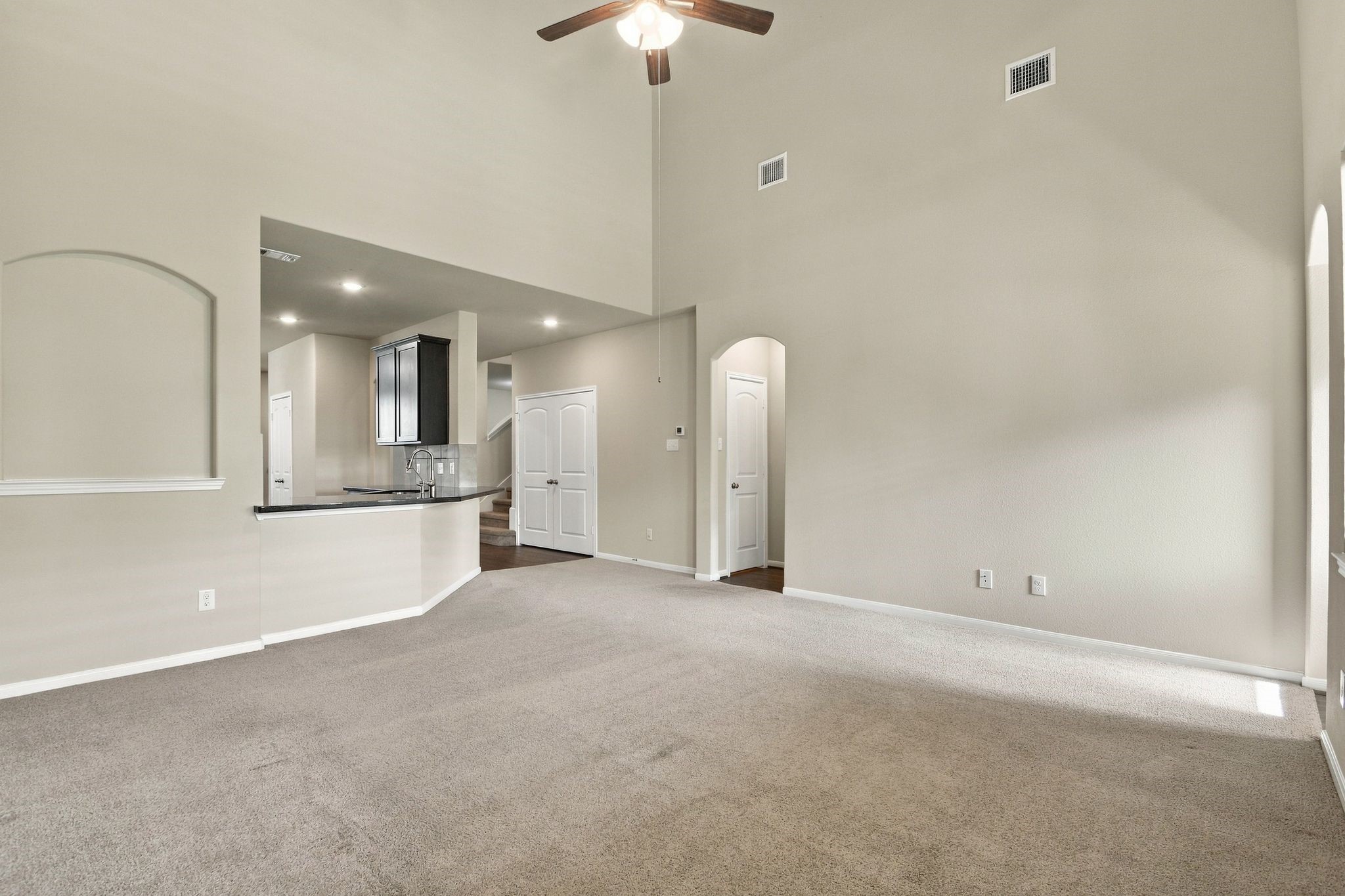 Living Room features tall ceilings and a fan