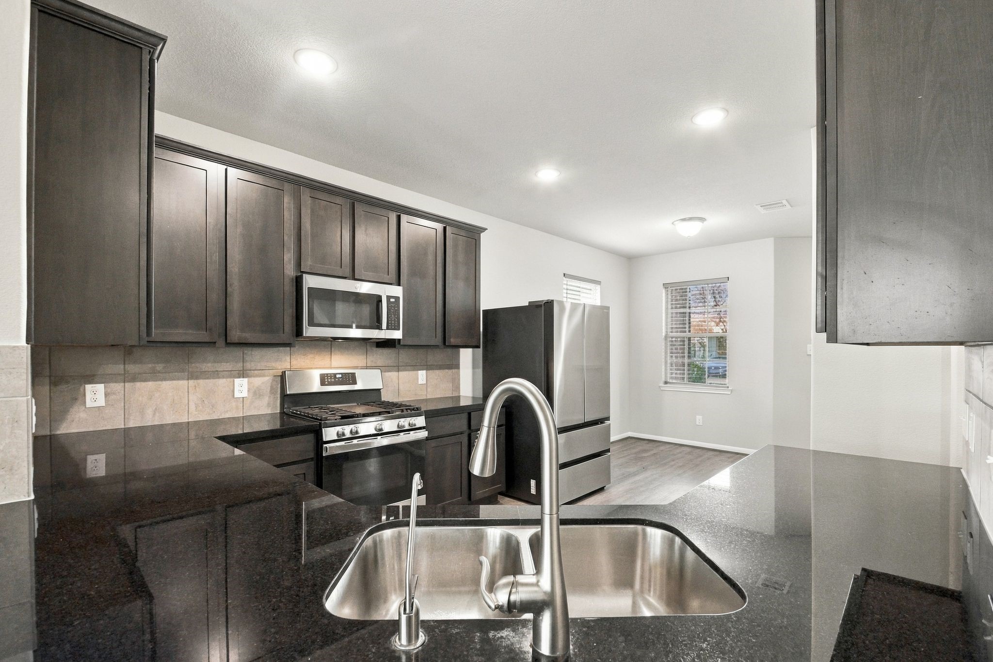 The kitchen features granite countertops and a high bar