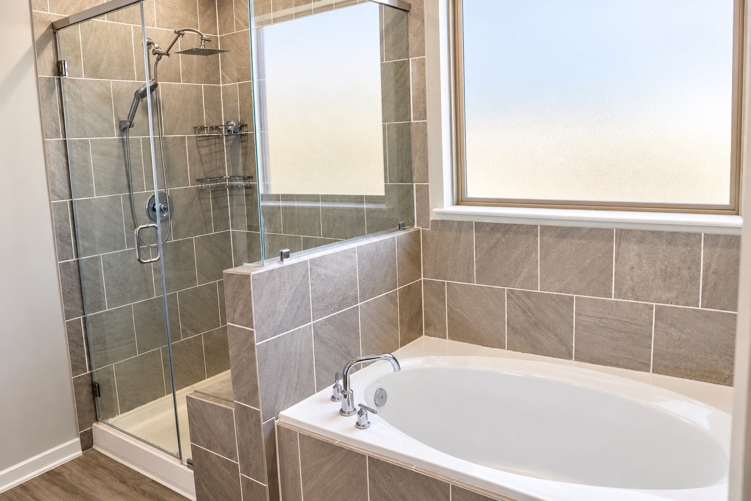 Primary bath featuring a separate soaking tub and spacious walk-in shower with glass enclosure, attractive tilework, and a window providing natural light.