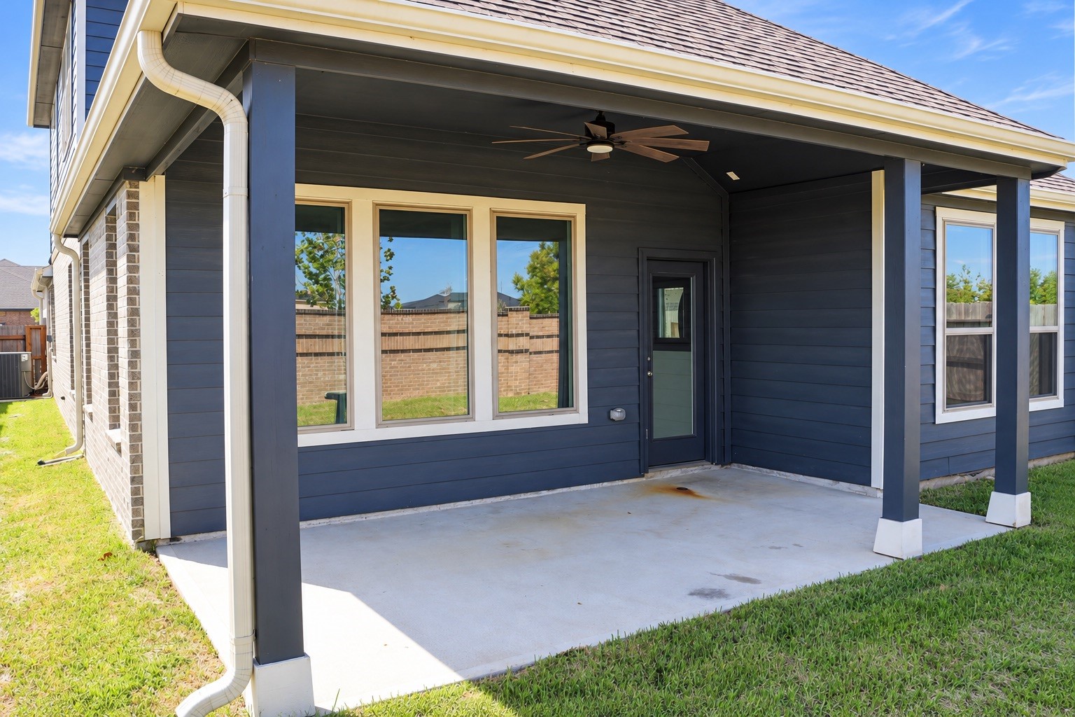 The covered back patio provides a comfortable space to relax, enjoy morning coffee, or unwind outdoors, while the backyard offers plenty of room for pets and play.