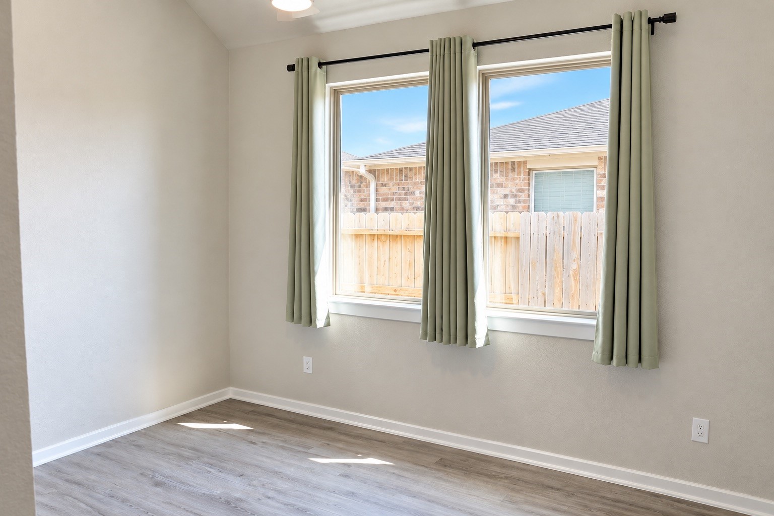 Versatile downstairs study featuring attractive flooring, neutral tones, and windows providing natural light. Ideal for a home office, reading room, or flexible space to suit your needs.