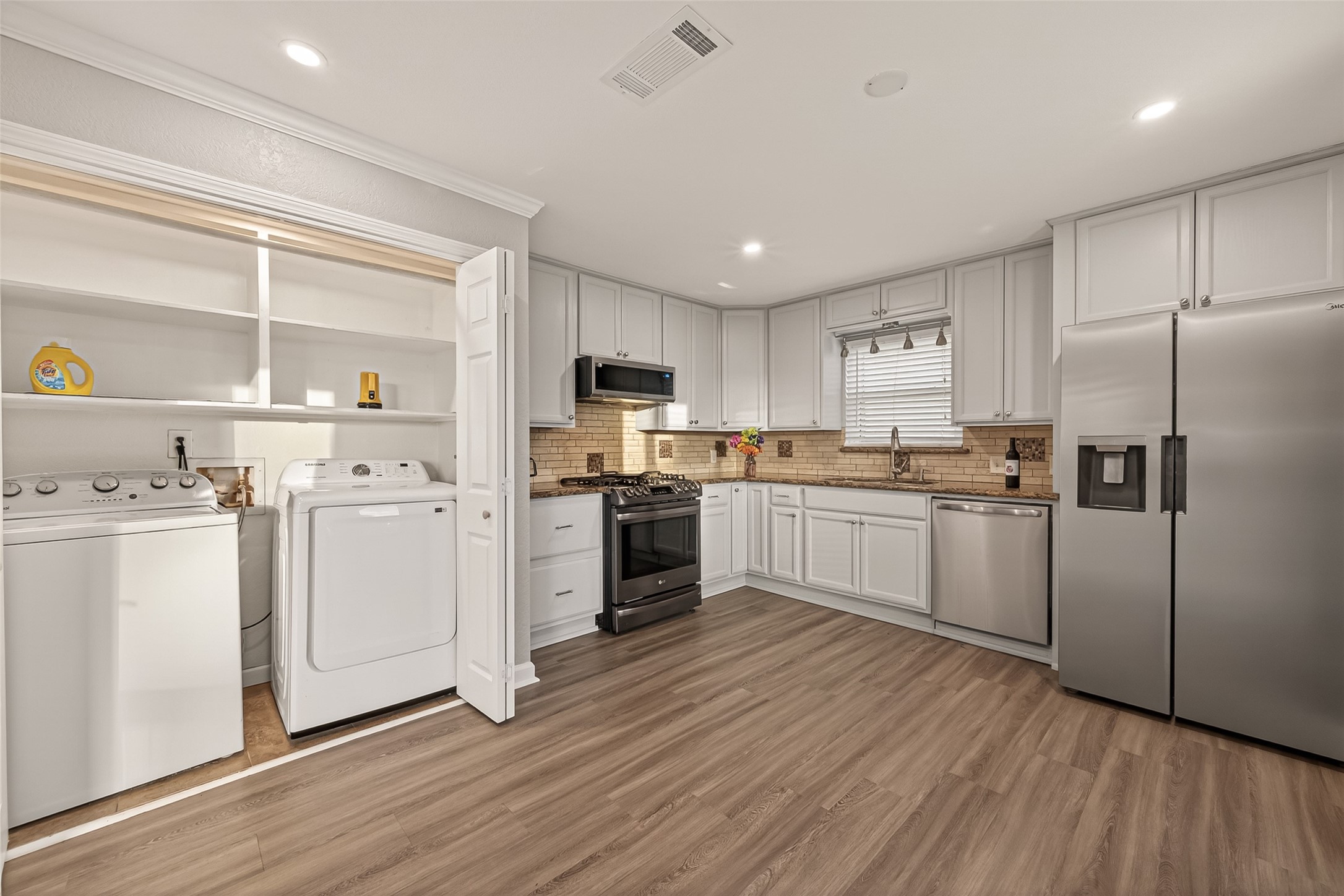Utility room adjacent to kitchen.  Washer/Dryer stay with the home as well as the Frig!  What a deal!