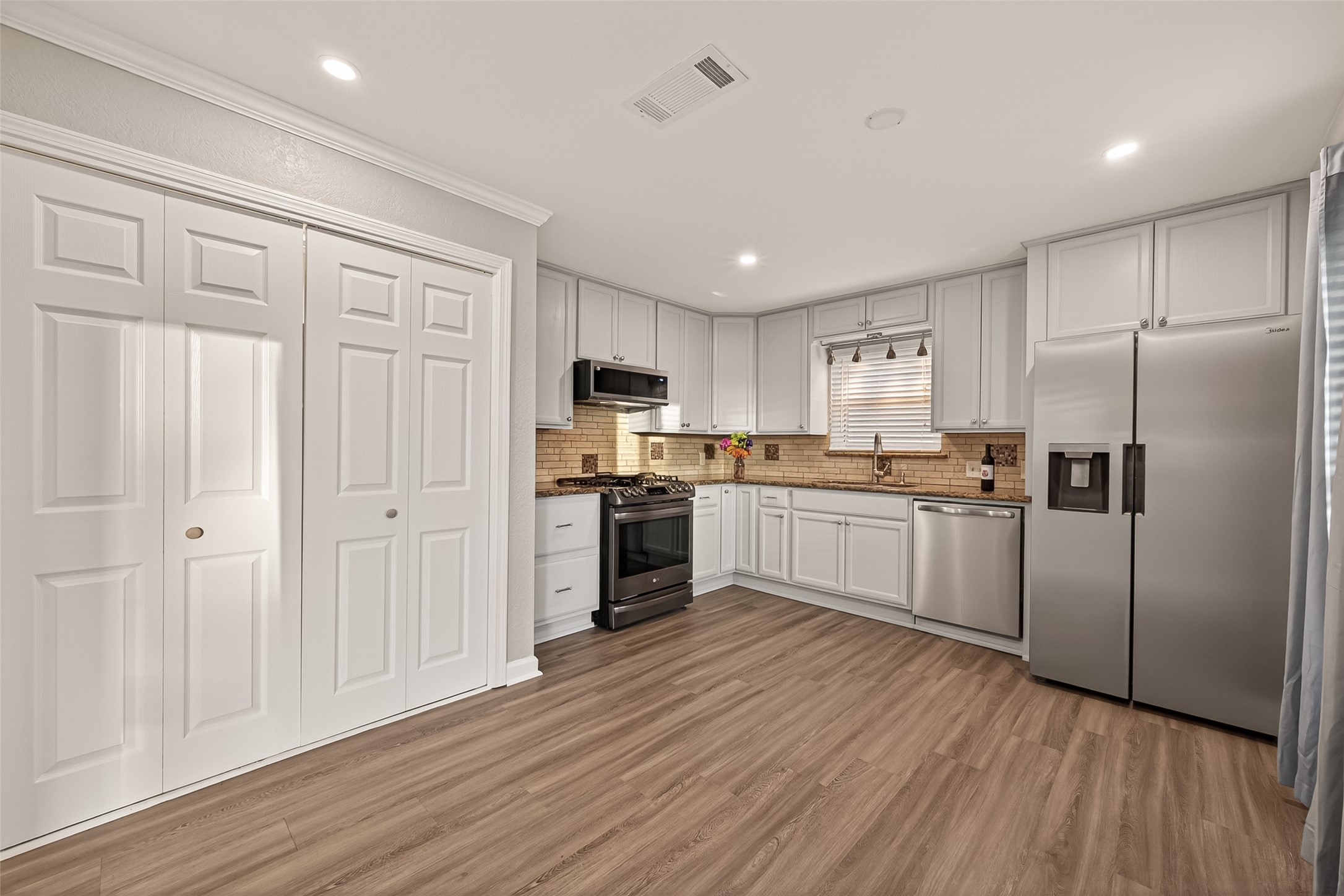 Another view of the kitchen/dining area with a washer/dryer behind the white doors.