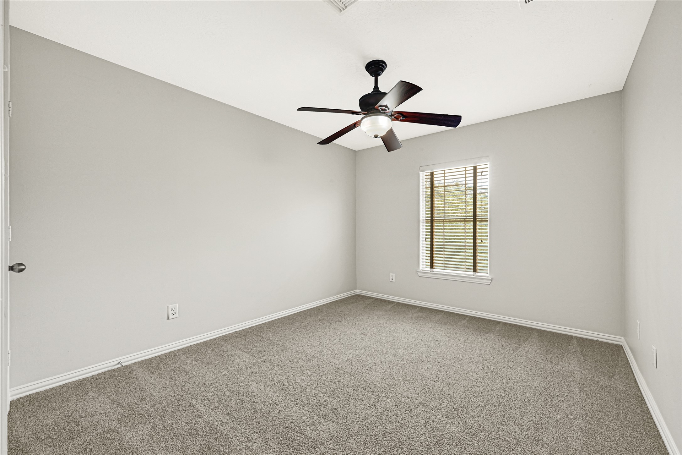 Bedroom 2 features a ceiling fan, fresh paint, and abundant natural light.