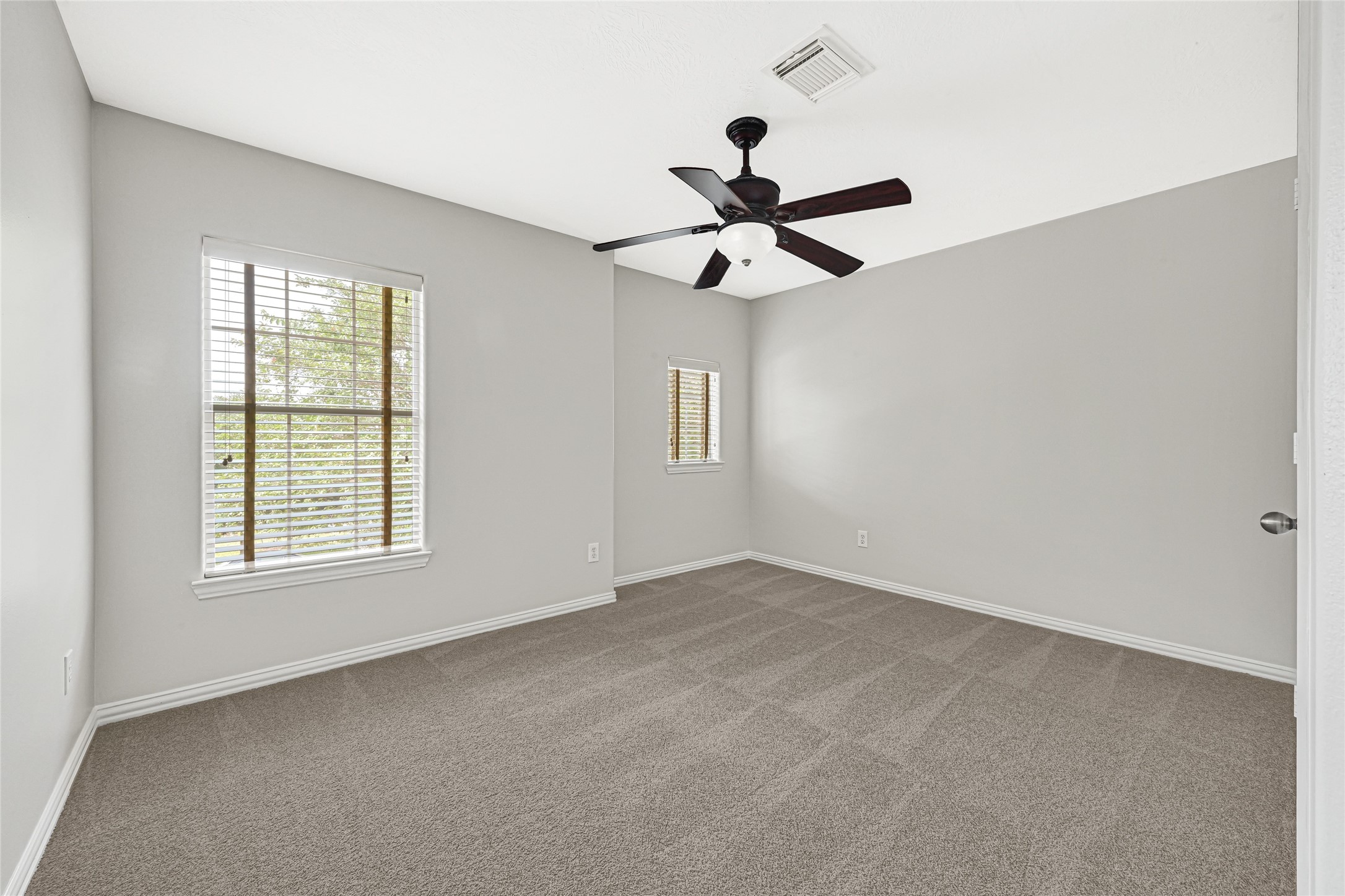 Comfortable Bedroom 1 with ceiling fan and beautiful large windows.
