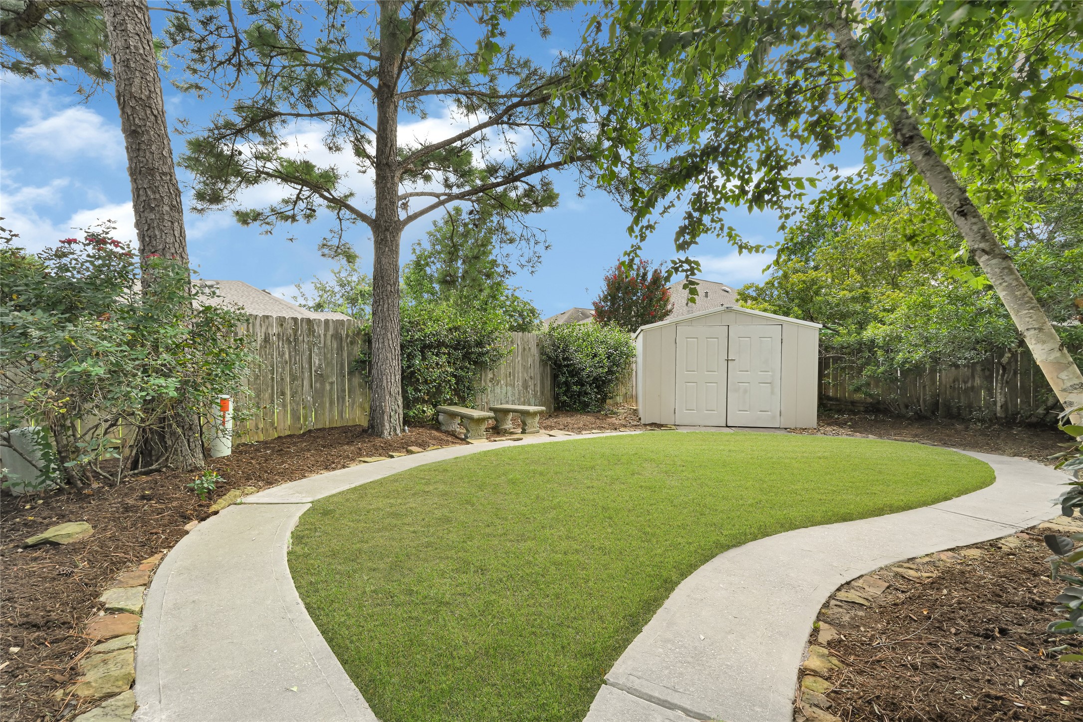 Manicured backyard with plenty of space to enjoy and a convenient storage shed.