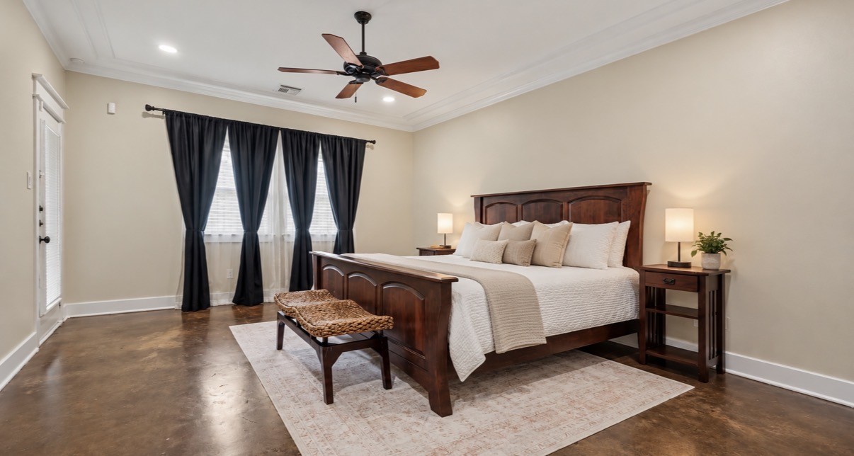 First floor primary bedroom is very spacious, with crown molding, custom trim and ceiling fan with door leading out to your private, fenced backyard oasis!