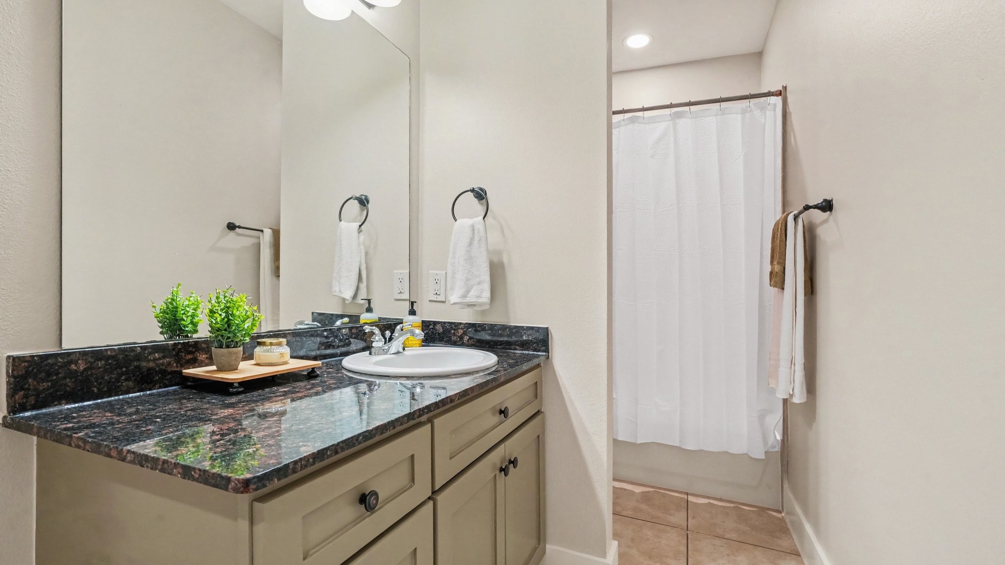 Full bathroom on second floor with large mirror, granite countertop and tub/shower combo