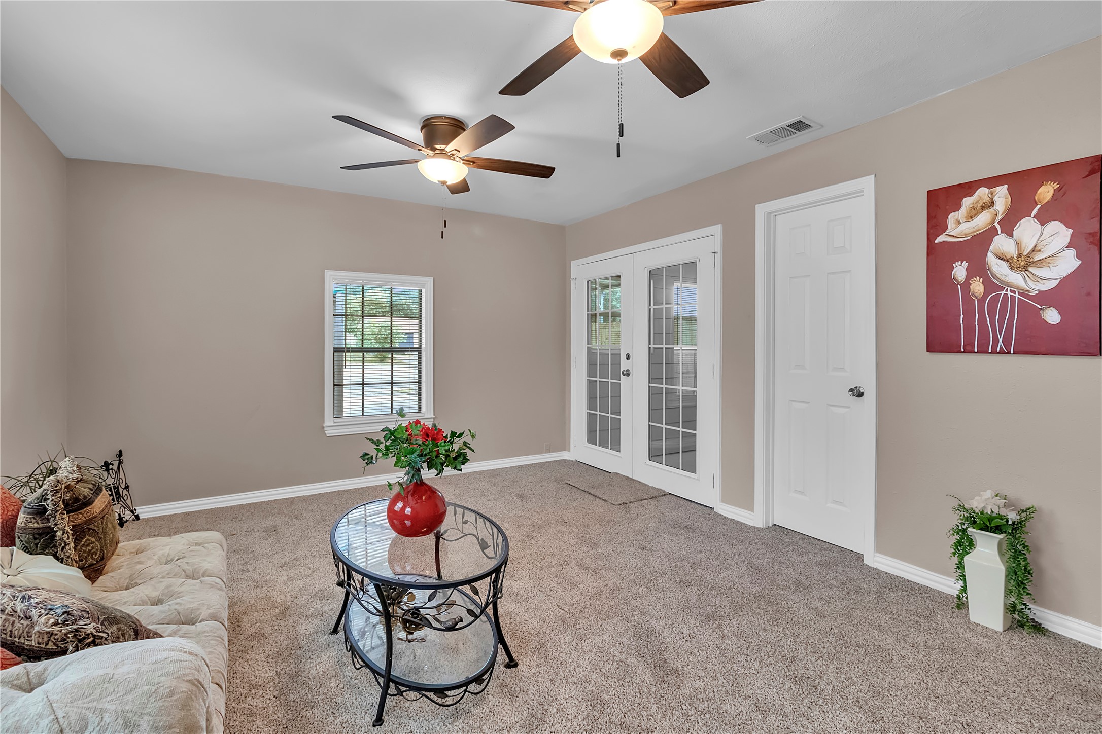 Additional view of the spacious primary featuring French doors leading to the sunroom Additional view of the spacious primary featuring French doors leading to the sunroom