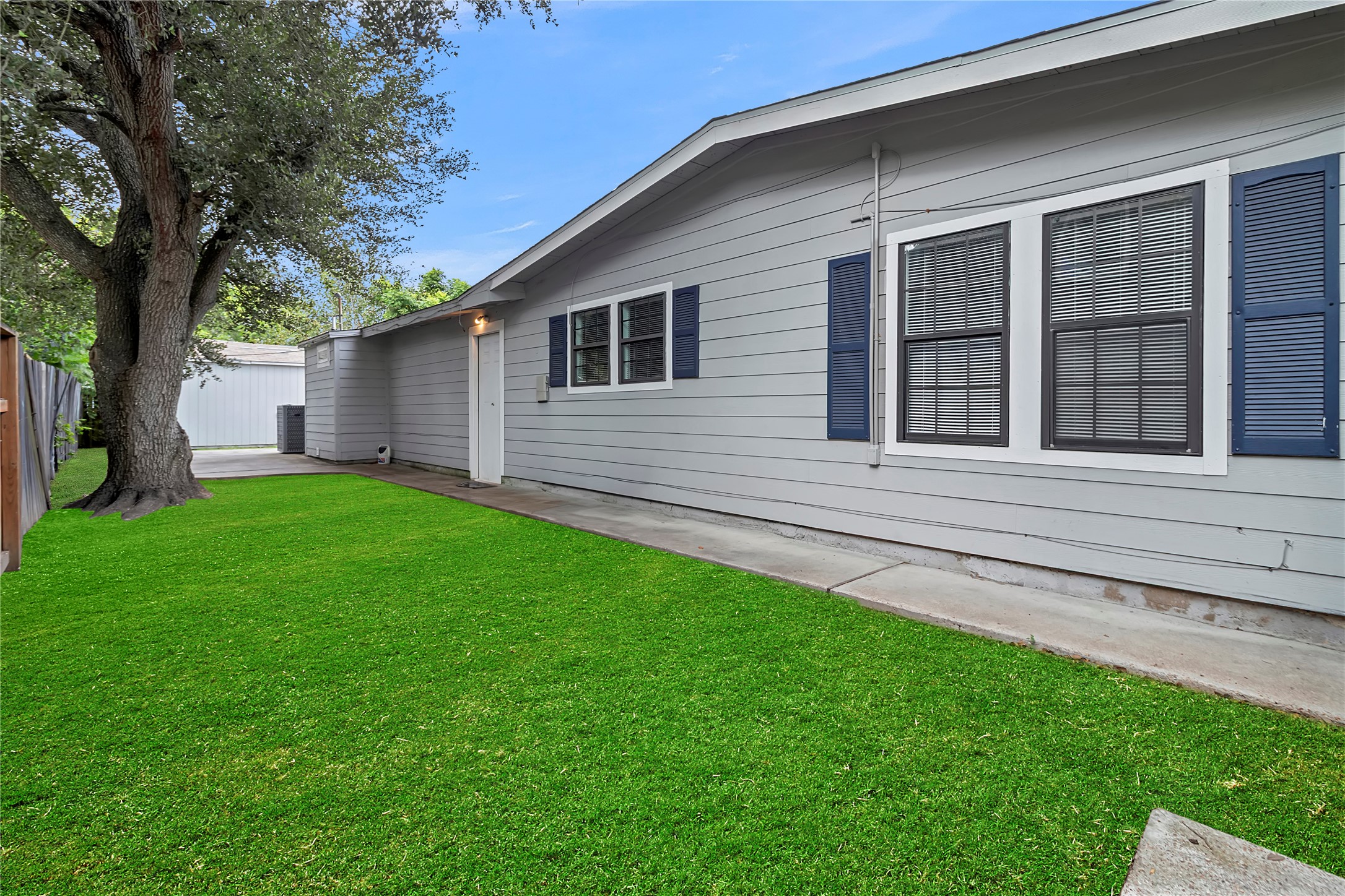 Private side yard with plenty of green space, mature shade tree, and direct access around the home.