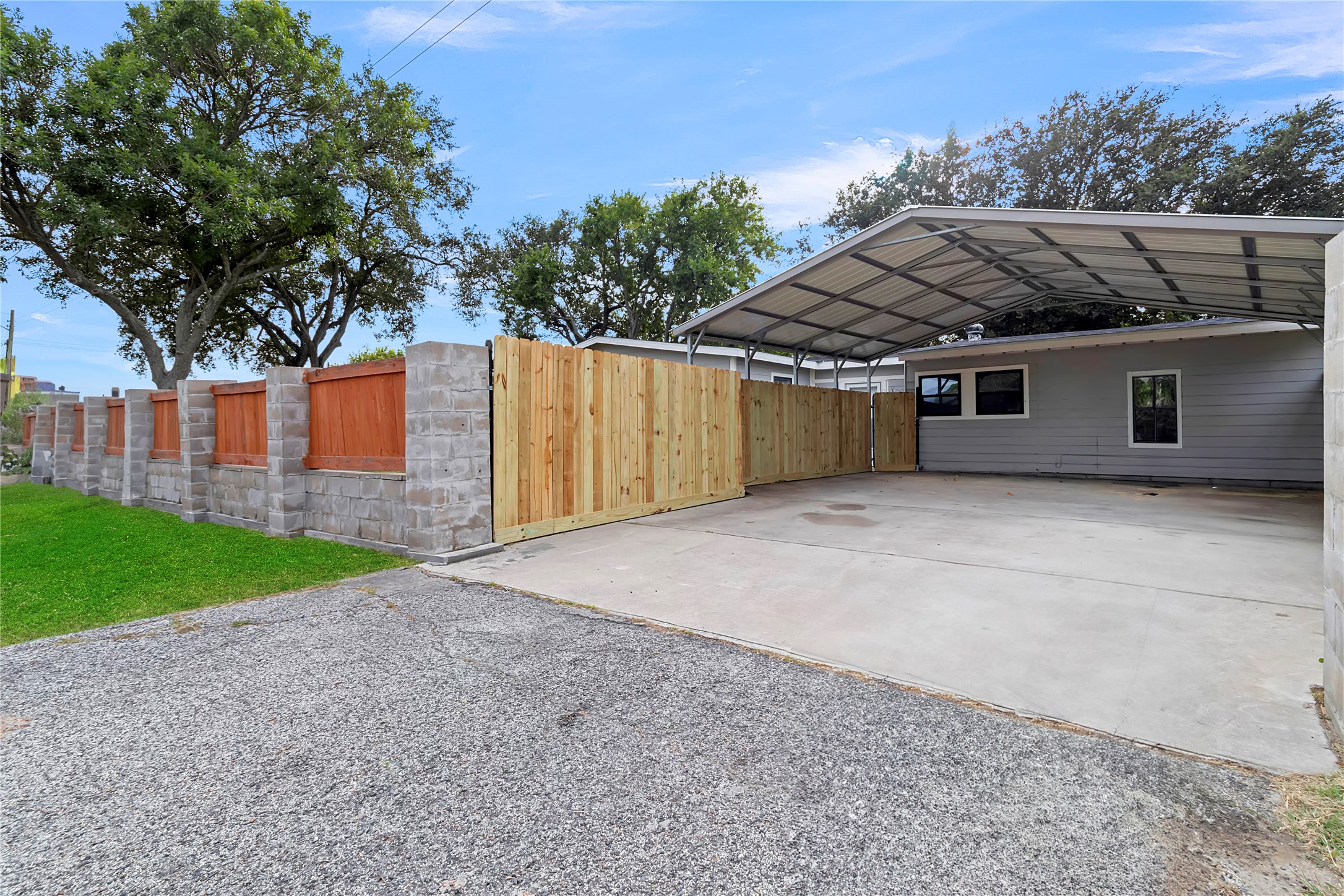Generous covered parking area with newly installed wood privacy fencing and convenient side access.