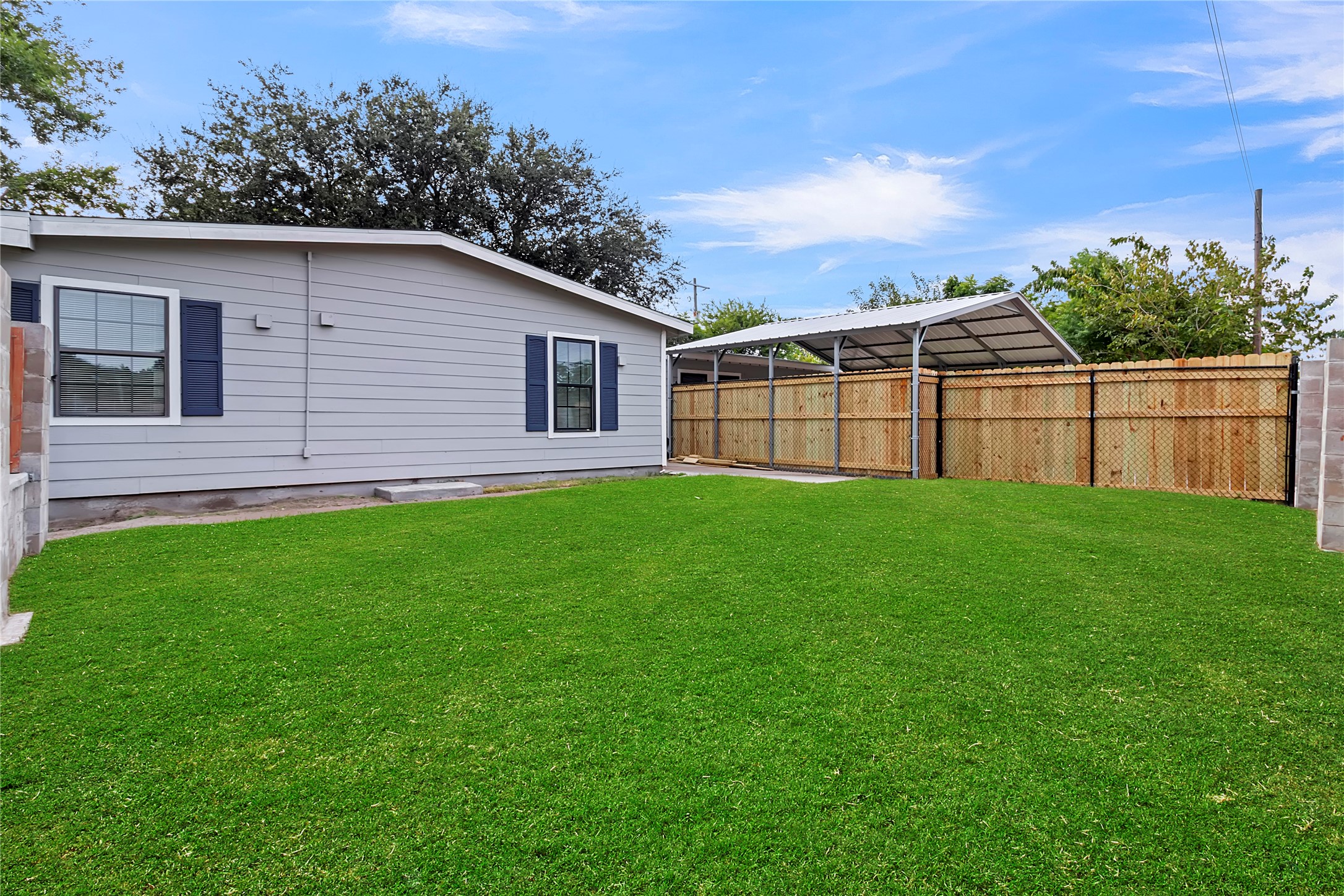 Large, fenced yard with covered parking and ample room for outdoor activities.