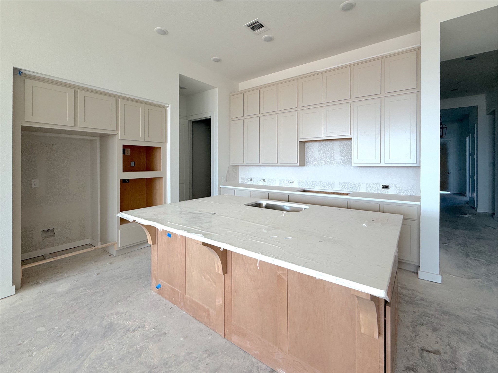 Designer kitchen featuring an oversized island with wrap around woodwork, stacked upper cabinets, and modern finishes Designer kitchen featuring an oversized island with wrap around woodwork, stacked upper cabinets, and modern finishes