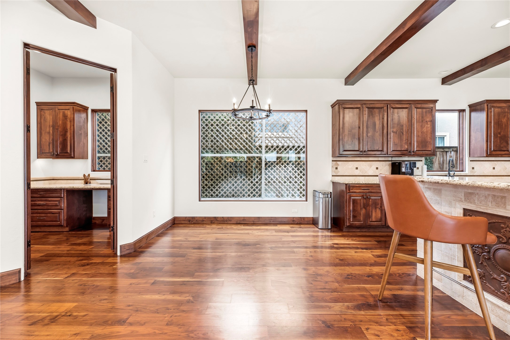 Adjacent to the kitchen, the bright breakfast area offers a comfortable spot for casual meals with views of the backyard greenery through large windows.