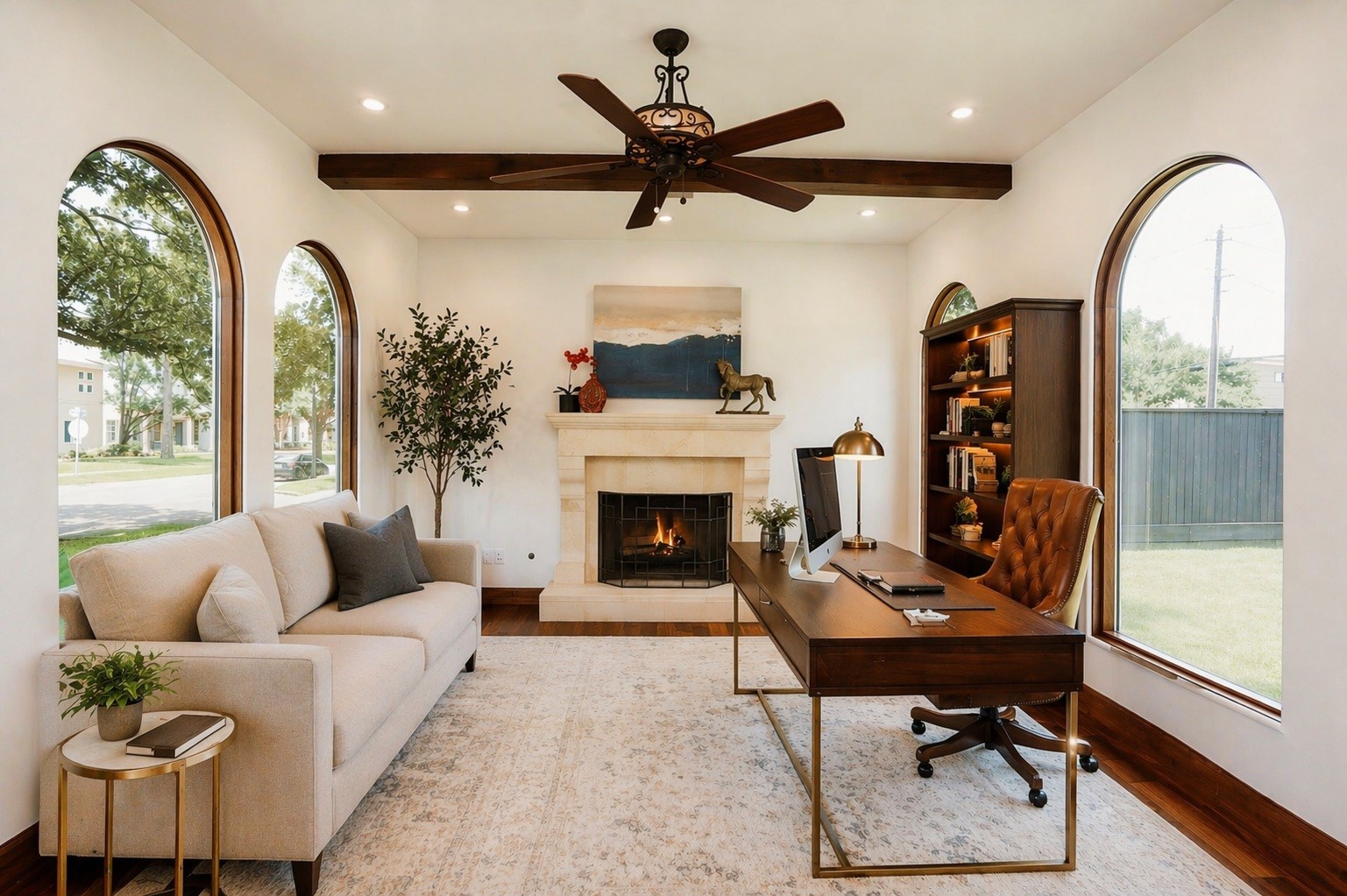 The dedicated home office features a stately fireplace, rich wood floors, and picturesque arched windows. This space combines architectural elegance with abundant natural light to create a quiet, productive environment. Virtually staged. The dedicated home office features a stately fireplace, rich wood floors, and picturesque arched windows. This space combines architectural elegance with abundant natural light to create a quiet, productive environment. Virtually staged.