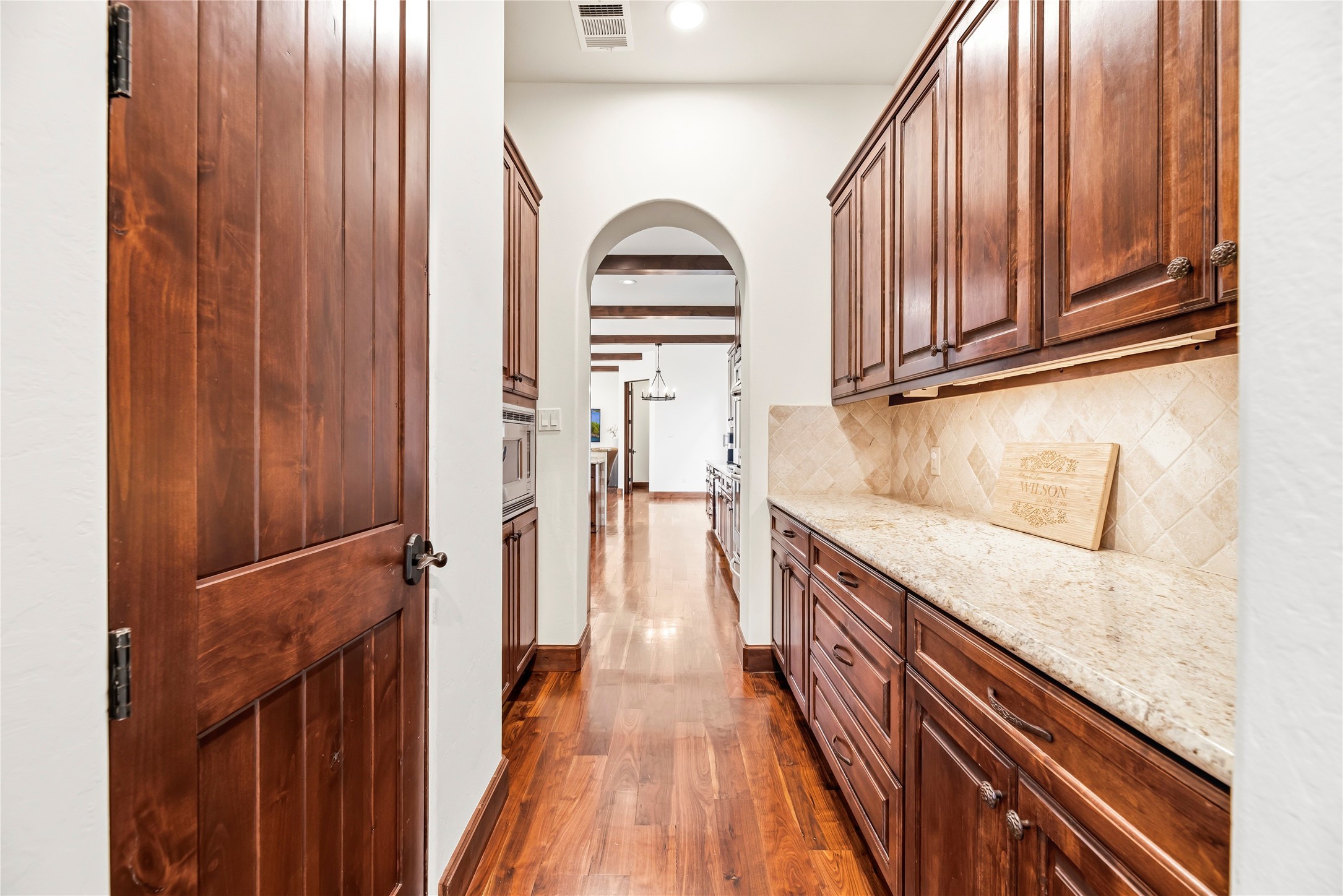 A refined butler's pantry offers additional granite counter space and storage, providing an elegant transition between the kitchen and formal dining areas.