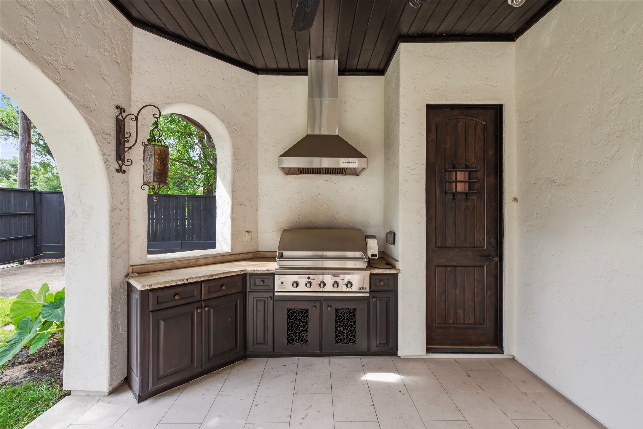 A professional-grade outdoor kitchen features a built-in gas grill and granite countertops, allowing for a refined dining experience in the open air.