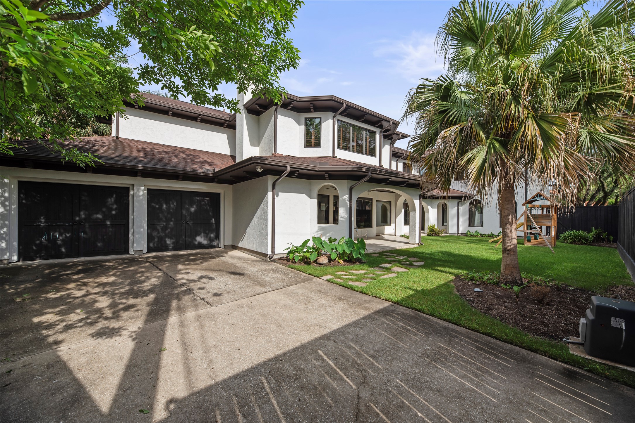 The oversized two-car garage is complemented by a wide driveway, providing ample space for vehicle storage and guest parking.