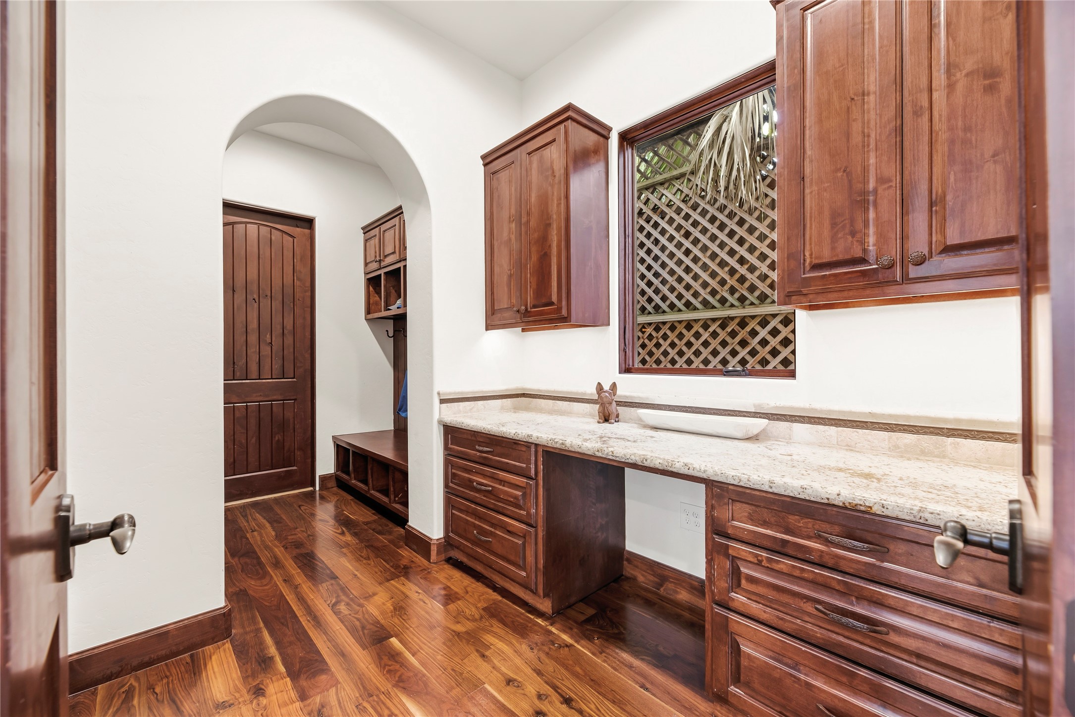 This practical study nook and mudroom combination features custom built-ins and granite surfaces, creating a refined yet efficient space for managing a busy household.