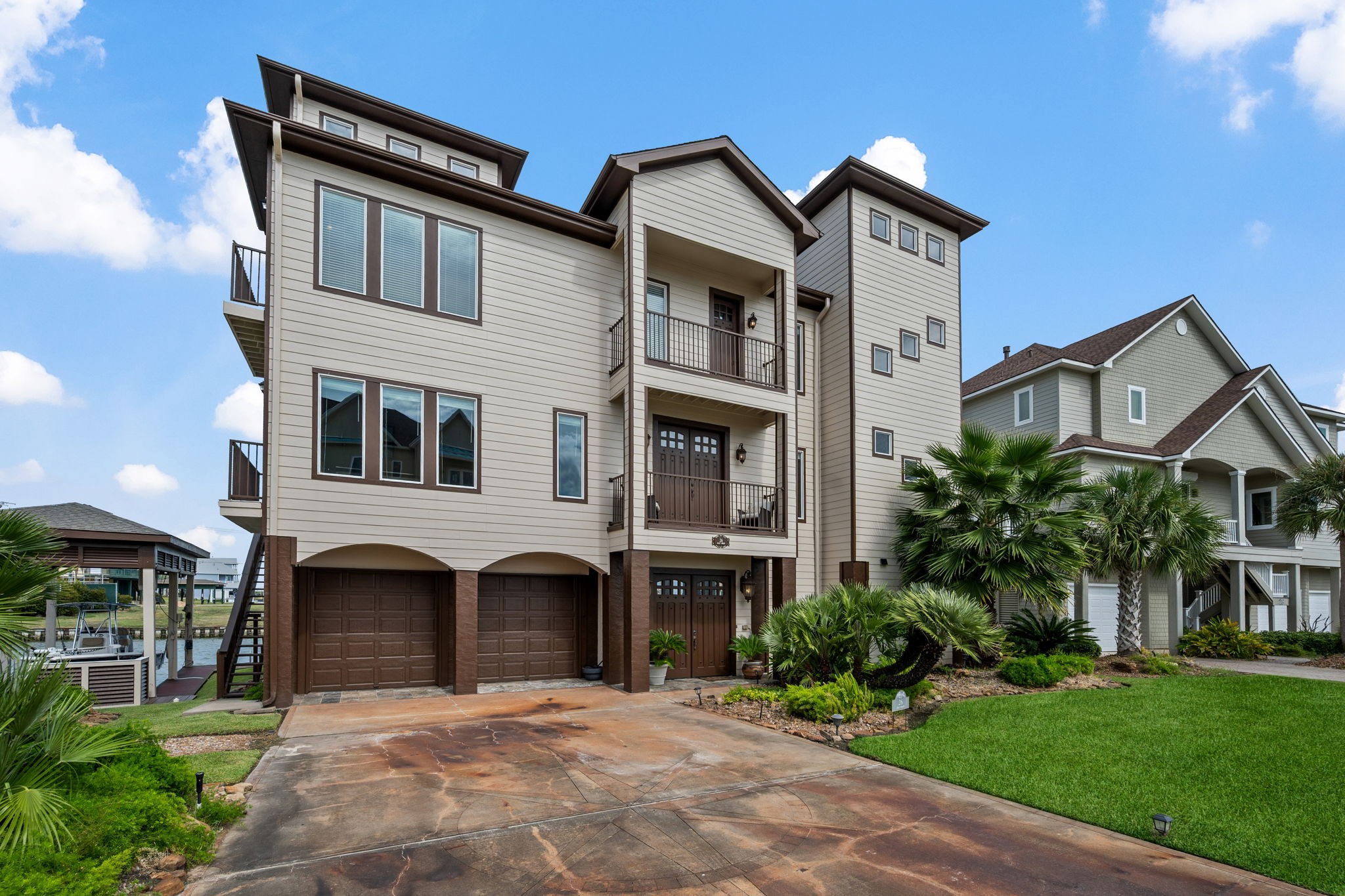 Stunning multi-story coastal home with a modern facade, expansive windows, and lush landscaping, offering ample garage space and a welcoming driveway. Stunning multi-story coastal home with a modern facade, expansive windows, and lush landscaping, offering ample garage space and a welcoming driveway.