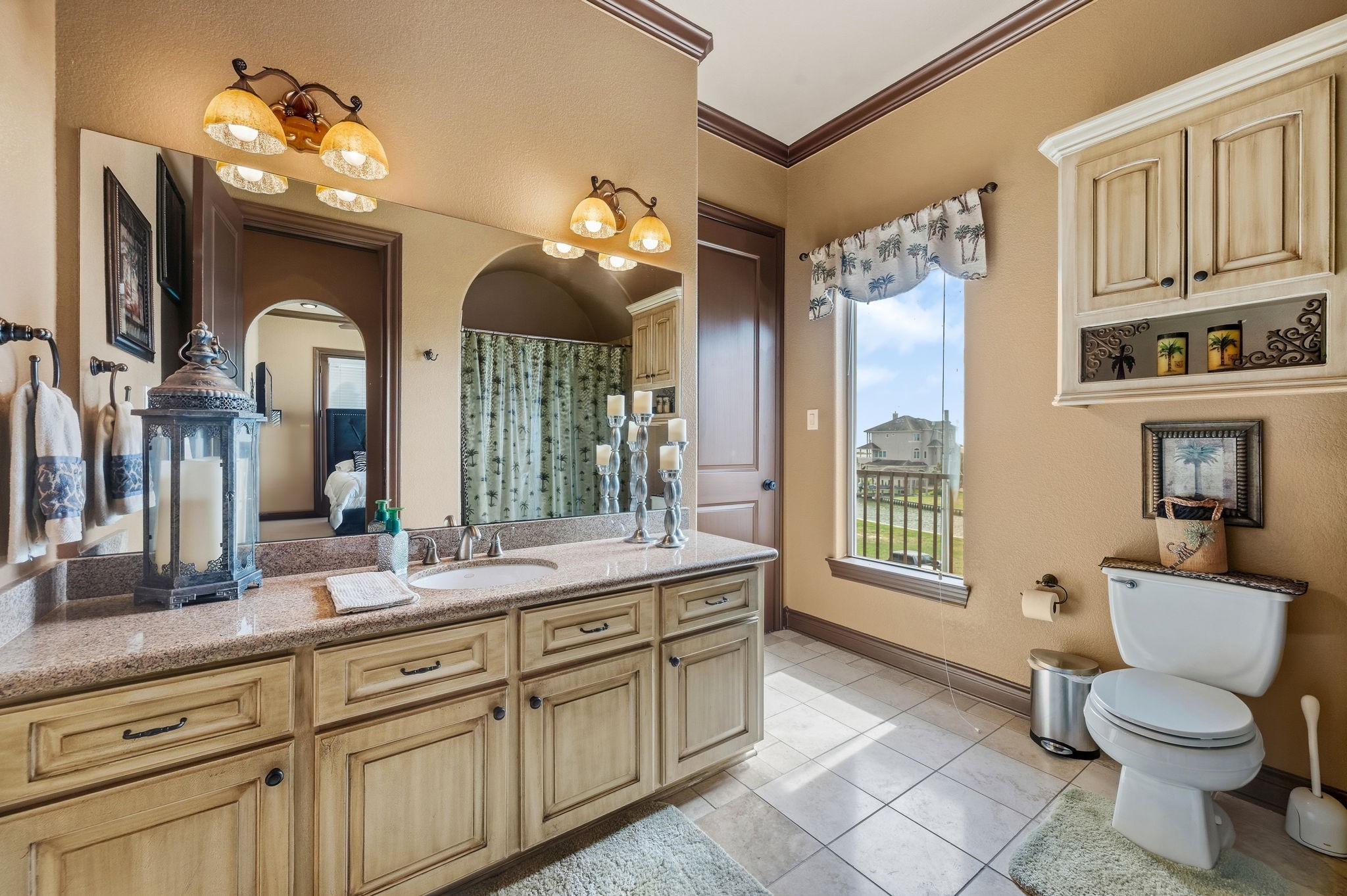 Spacious Jack and Jill bathroom with dual sinks, warm lighting, and a spacious vanity, complemented by a large window offering natural light and scenic views.
