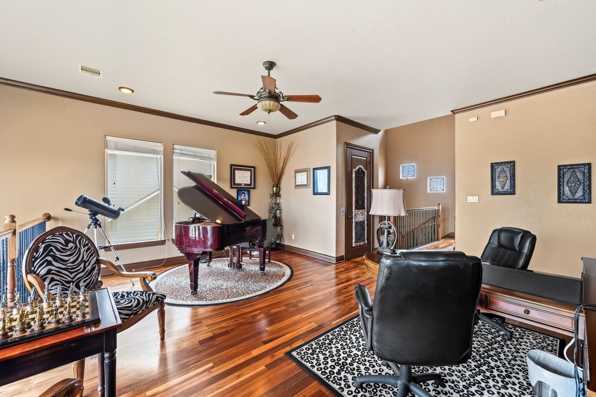 Elegant study with rich hardwood floors, featuring a grand piano and a cozy seating area, perfect for relaxation or creative pursuits.