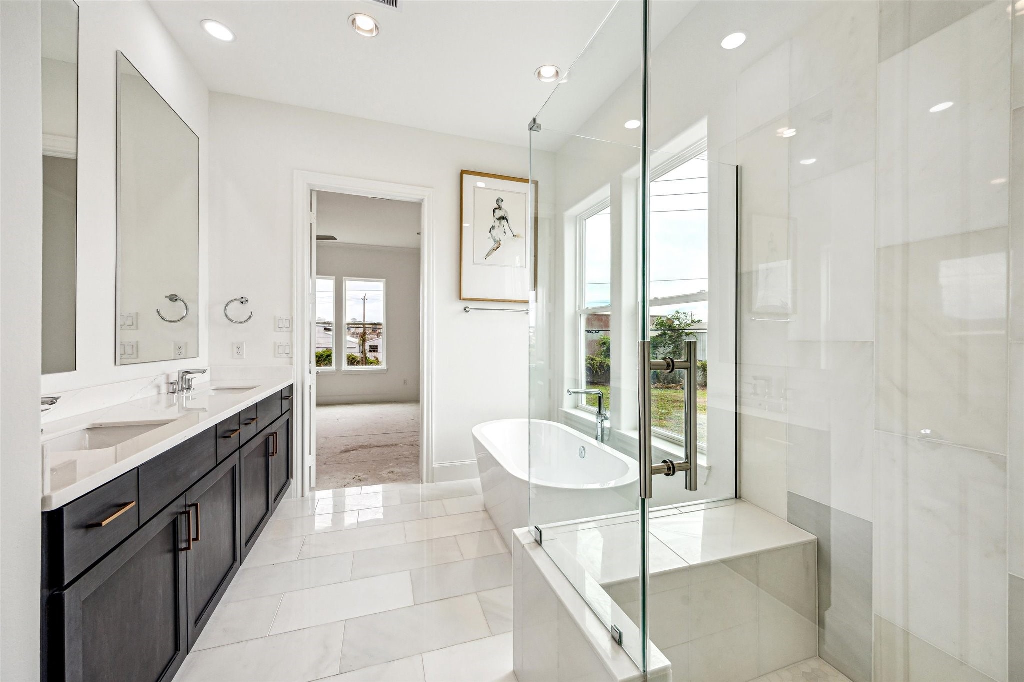 gorgeous white marble slab luxe primary bath with natural light and windows