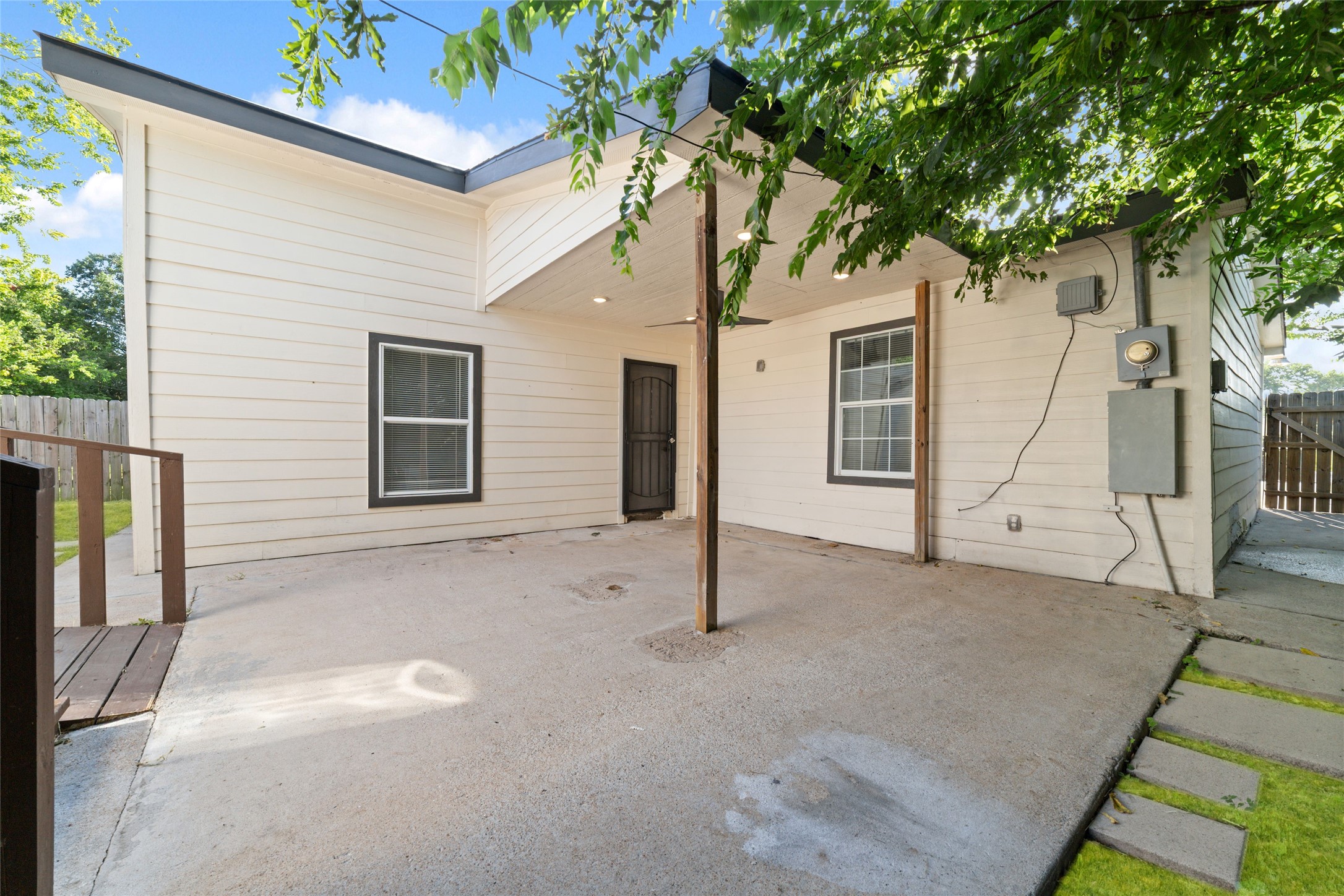Stepping outside into the covered backyard patio with two additional dwellings (each with HVAC).