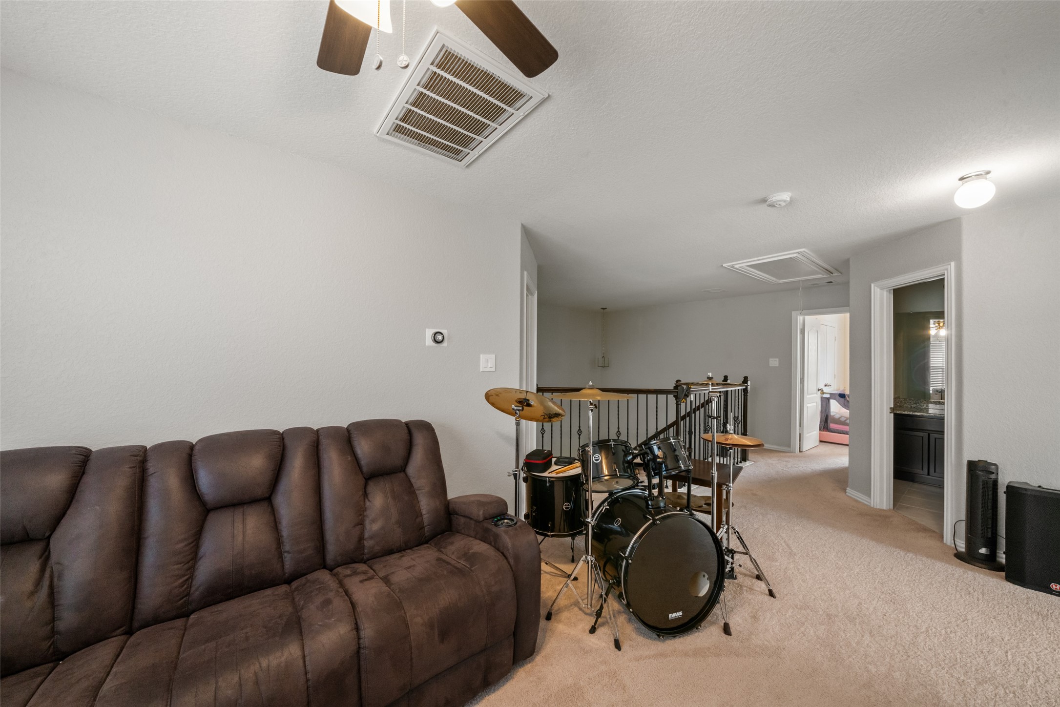 Spacious upstairs area featuring a cozy seating nook and room for entertainment, ideal for relaxation or hobbies.
