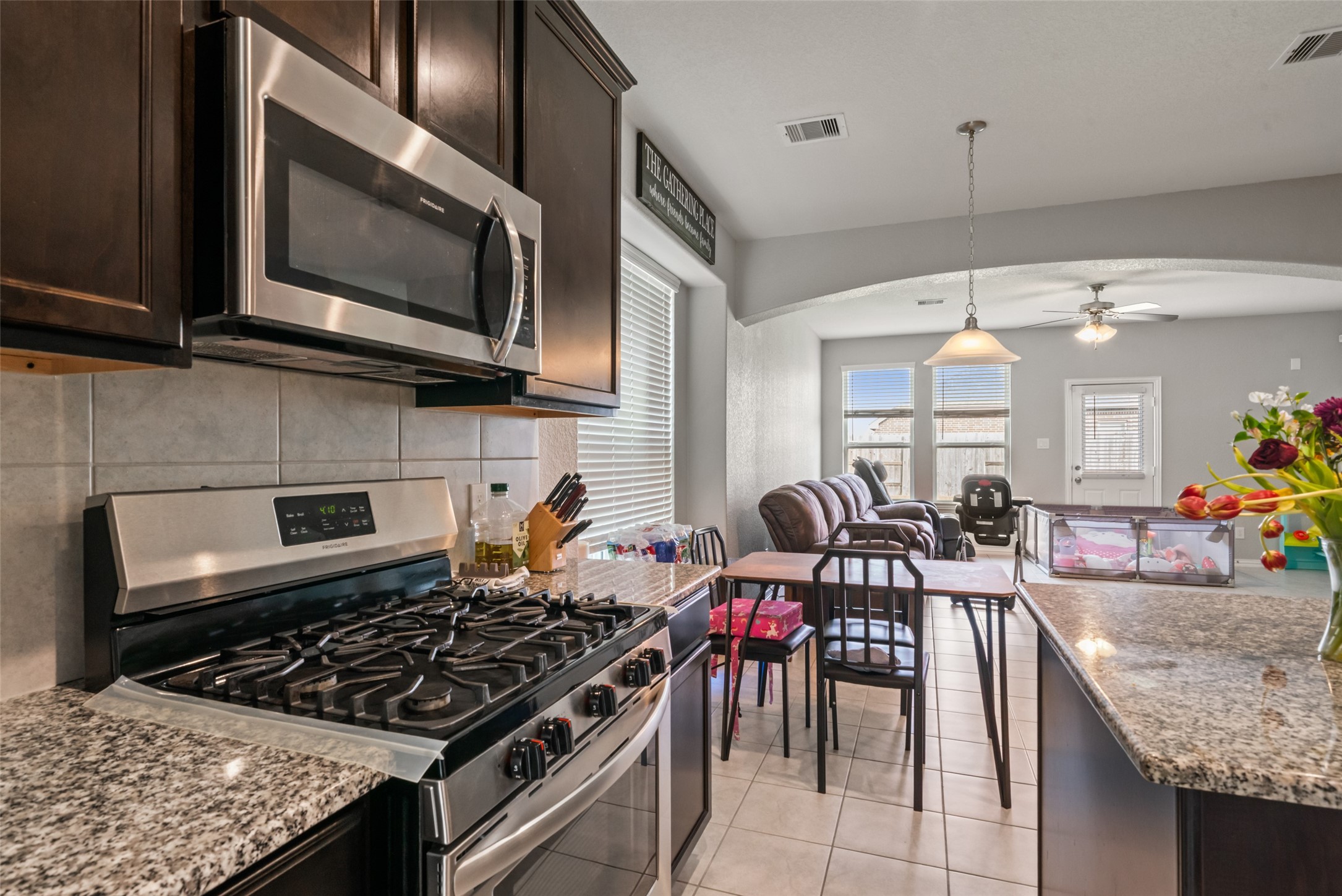 Modern kitchen with sleek stainless steel appliances, granite countertops, and an open layout that flows into a cozy living area.