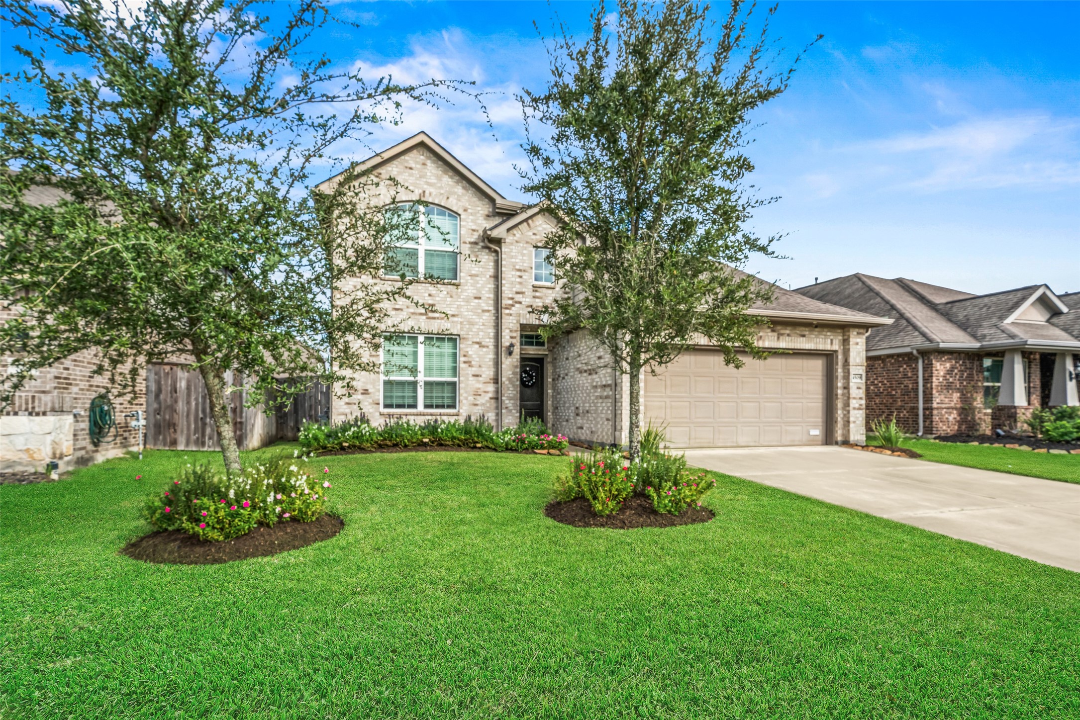 Appealing two-story brick home with a well-maintained lawn and vibrant landscaping, featuring a spacious driveway leading to an attached two-car garage. Appealing two-story brick home with a well-maintained lawn and vibrant landscaping, featuring a spacious driveway leading to an attached two-car garage.