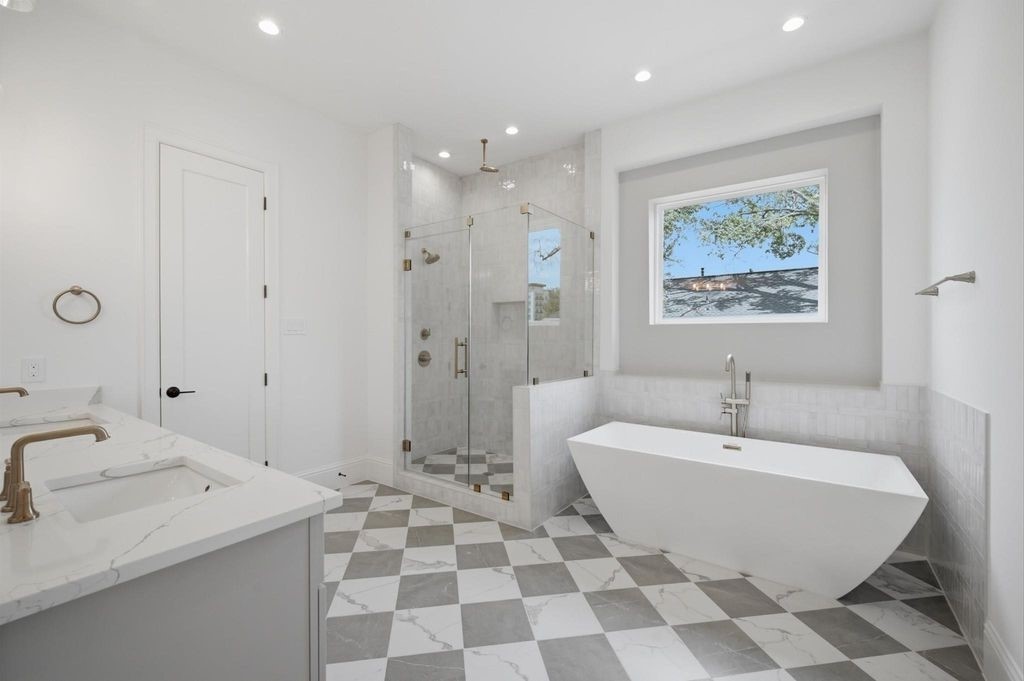 Primary bathroom offers a walk-in shower and stand alone soaking tub