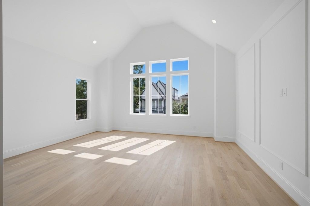 Primary bedroom features vaulted ceilings and abundant natural light.