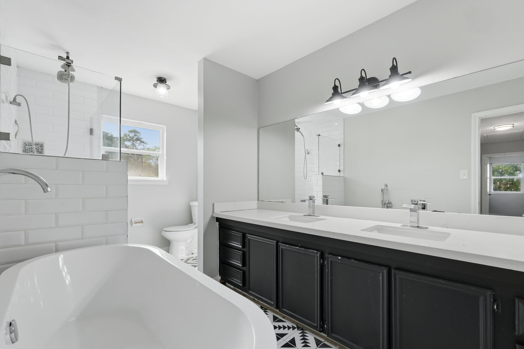 This elegant bathroom has a large soaking bathtub and a lovely adjacent rainfall shower.