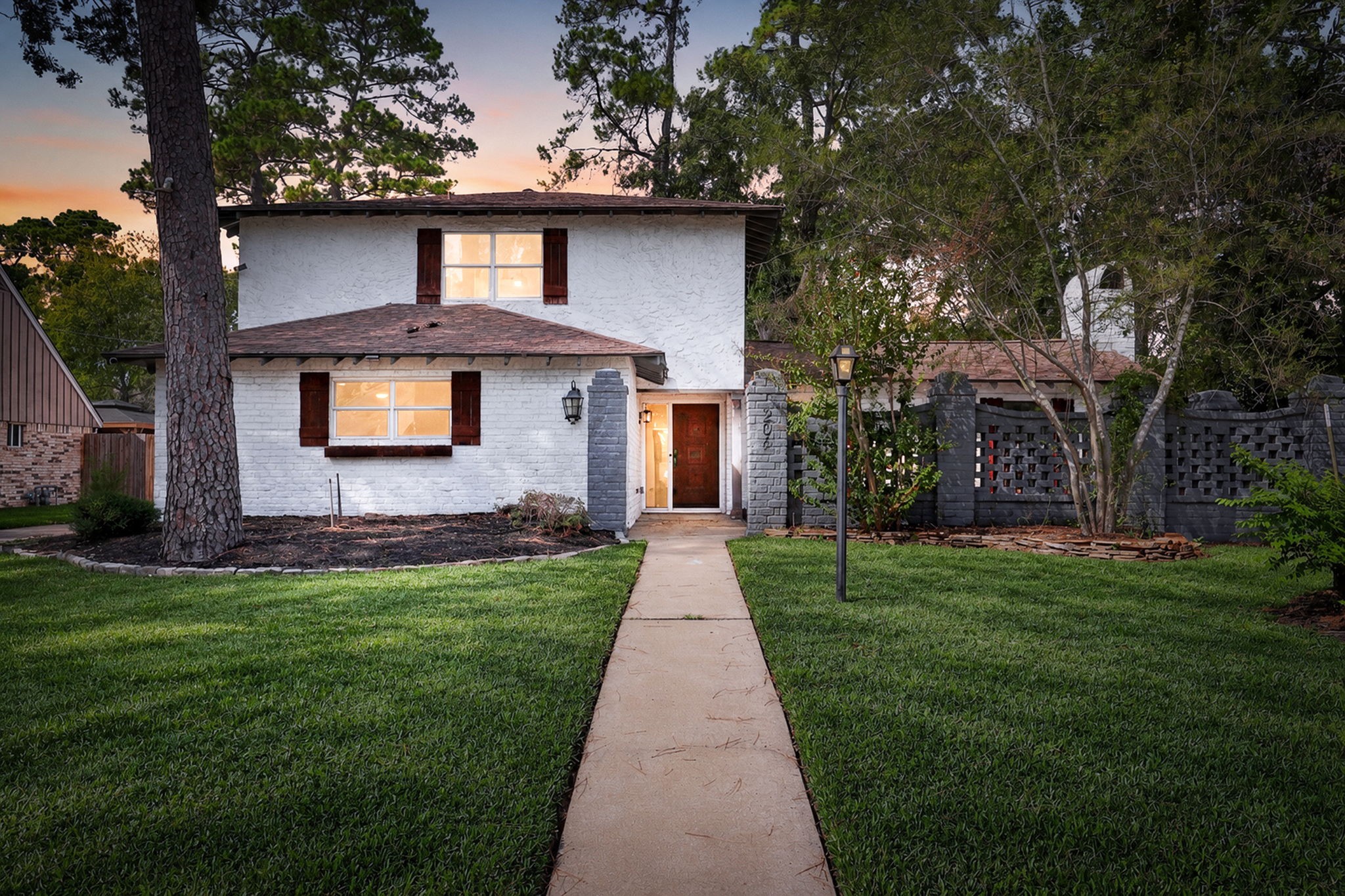Beautiful two-story home with a classic white brick exterior and warm accents.