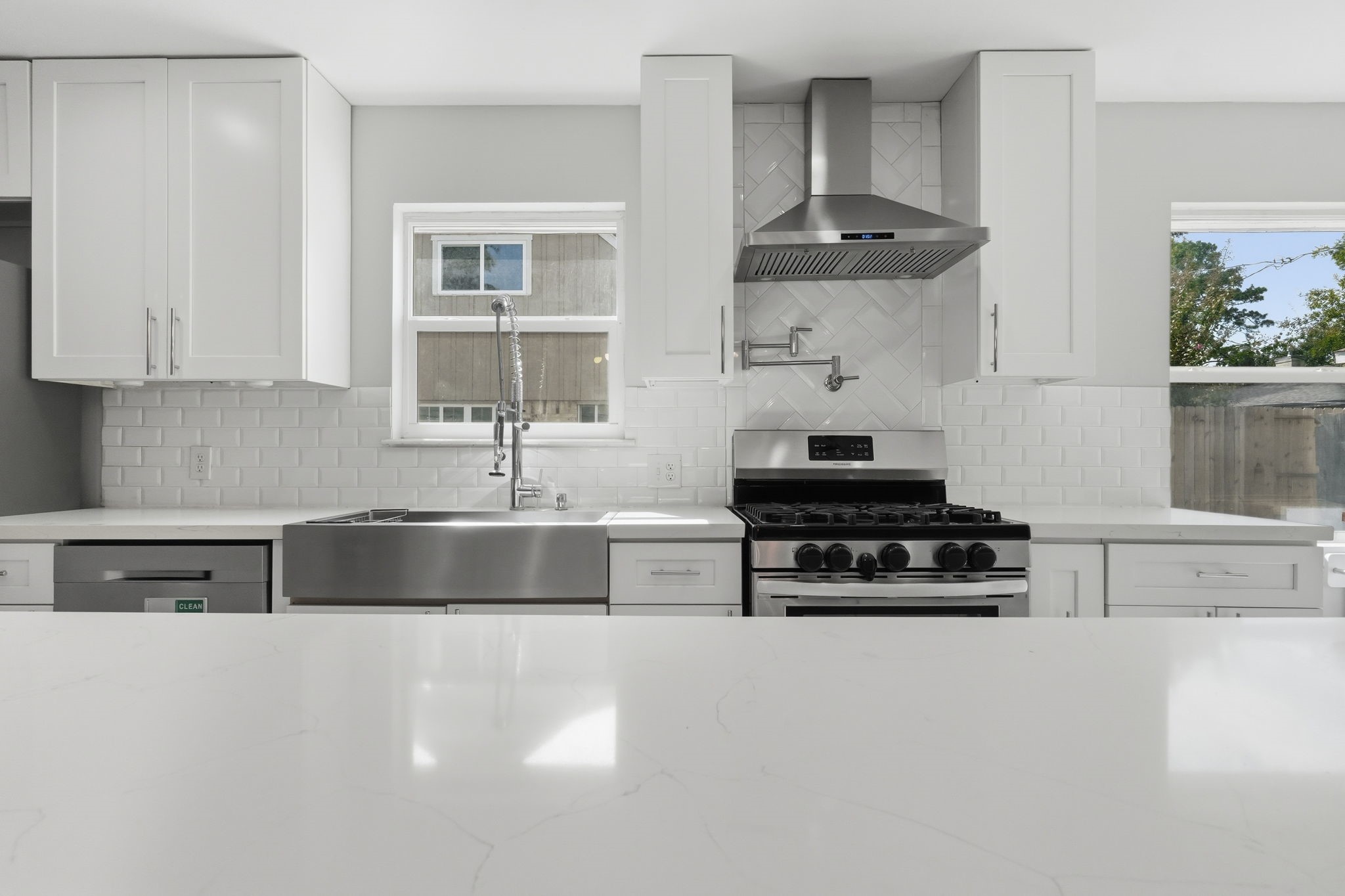 The kitchen features a large farmhouse sink with subway tile backsplash.