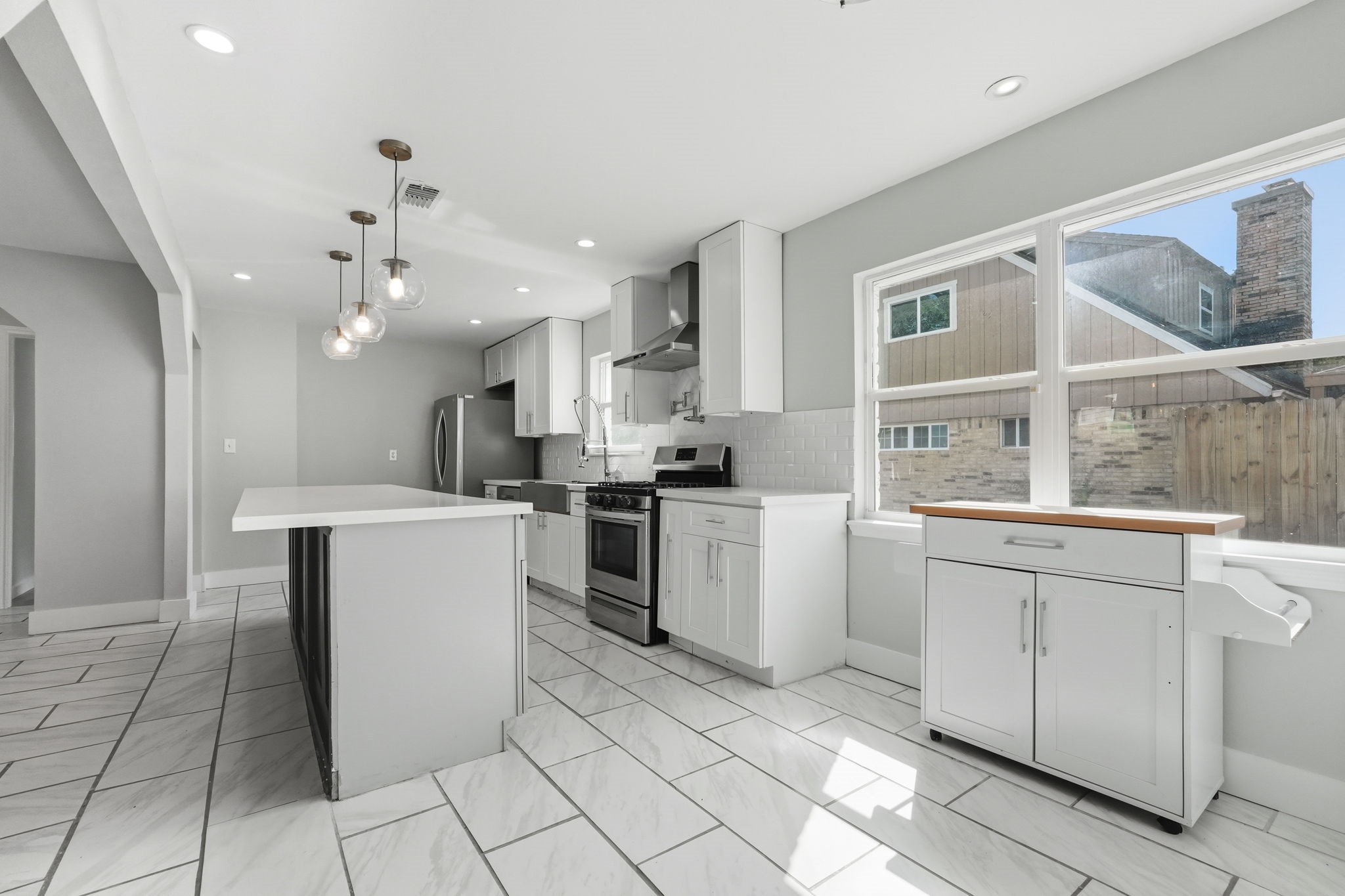Bright and modern kitchen featuring sleek stainless steel appliances, elegant white cabinetry.