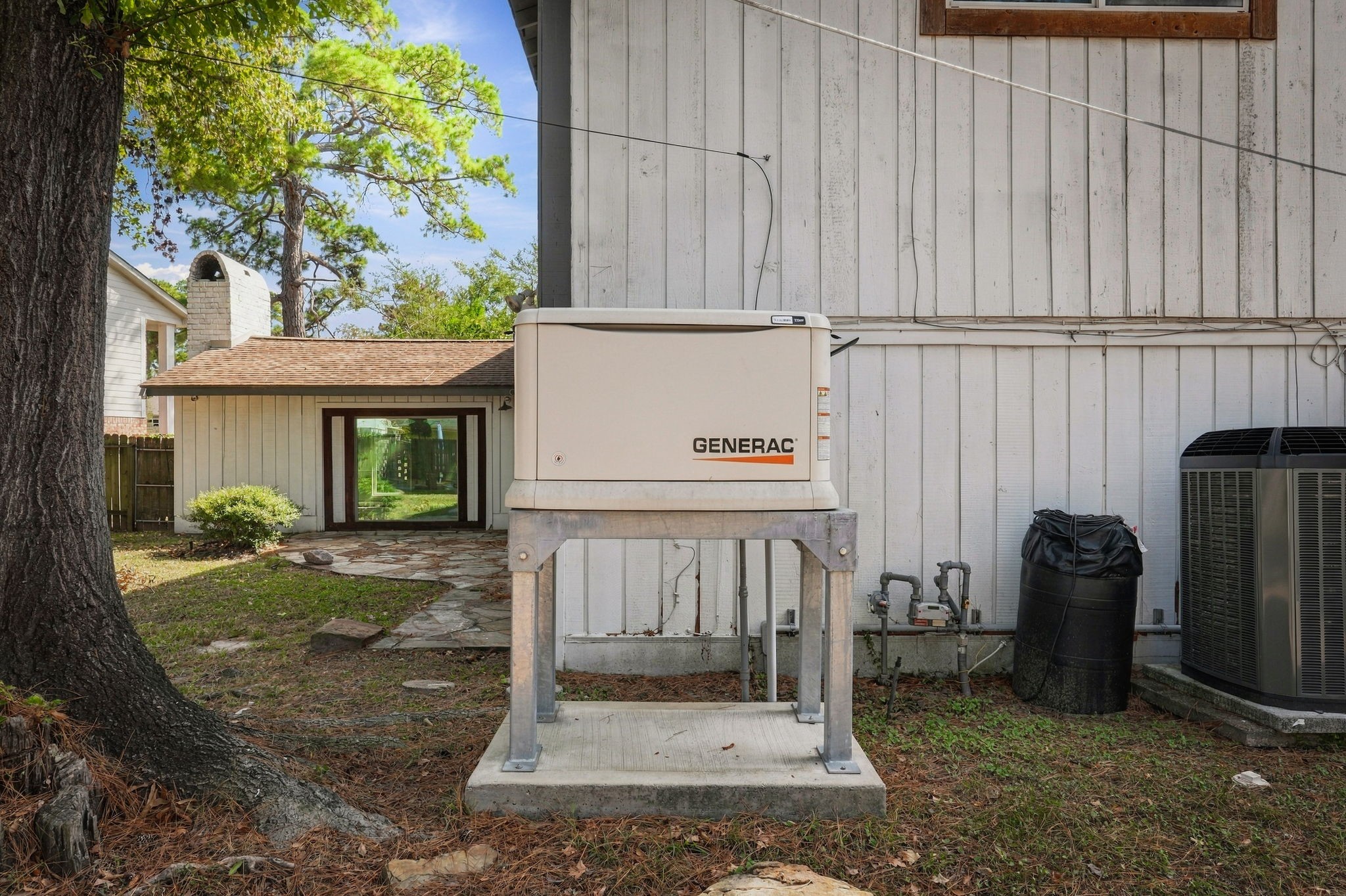 This house is equipped with a reliable Generac generator, ensuring continuous power supply. This property offers peace of mind alongside its charming exterior and lush surroundings.