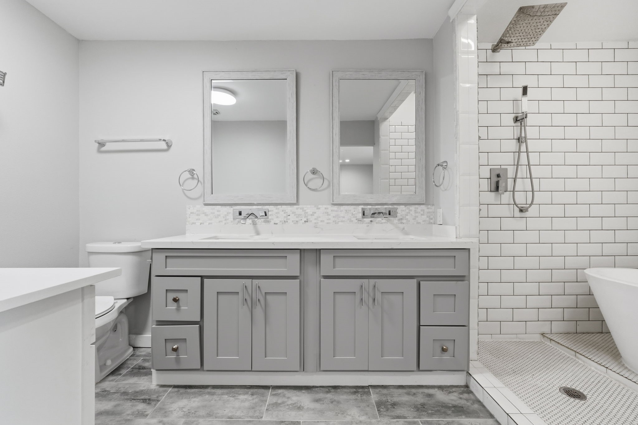 This bathroom features a dual-sink vanity with elegant gray cabinetry.