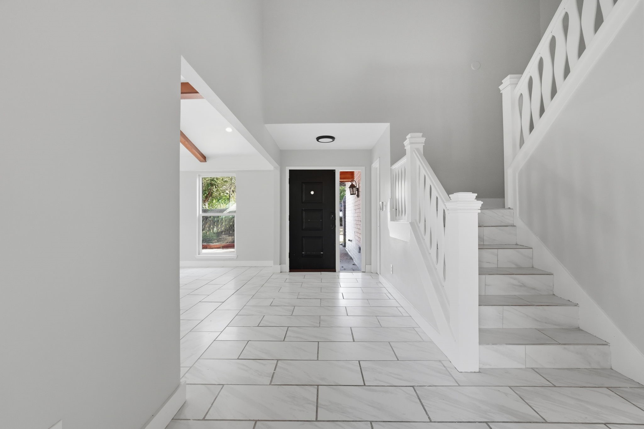 This opposite view of the grand entry way shows the connection to the living room and the stairs.