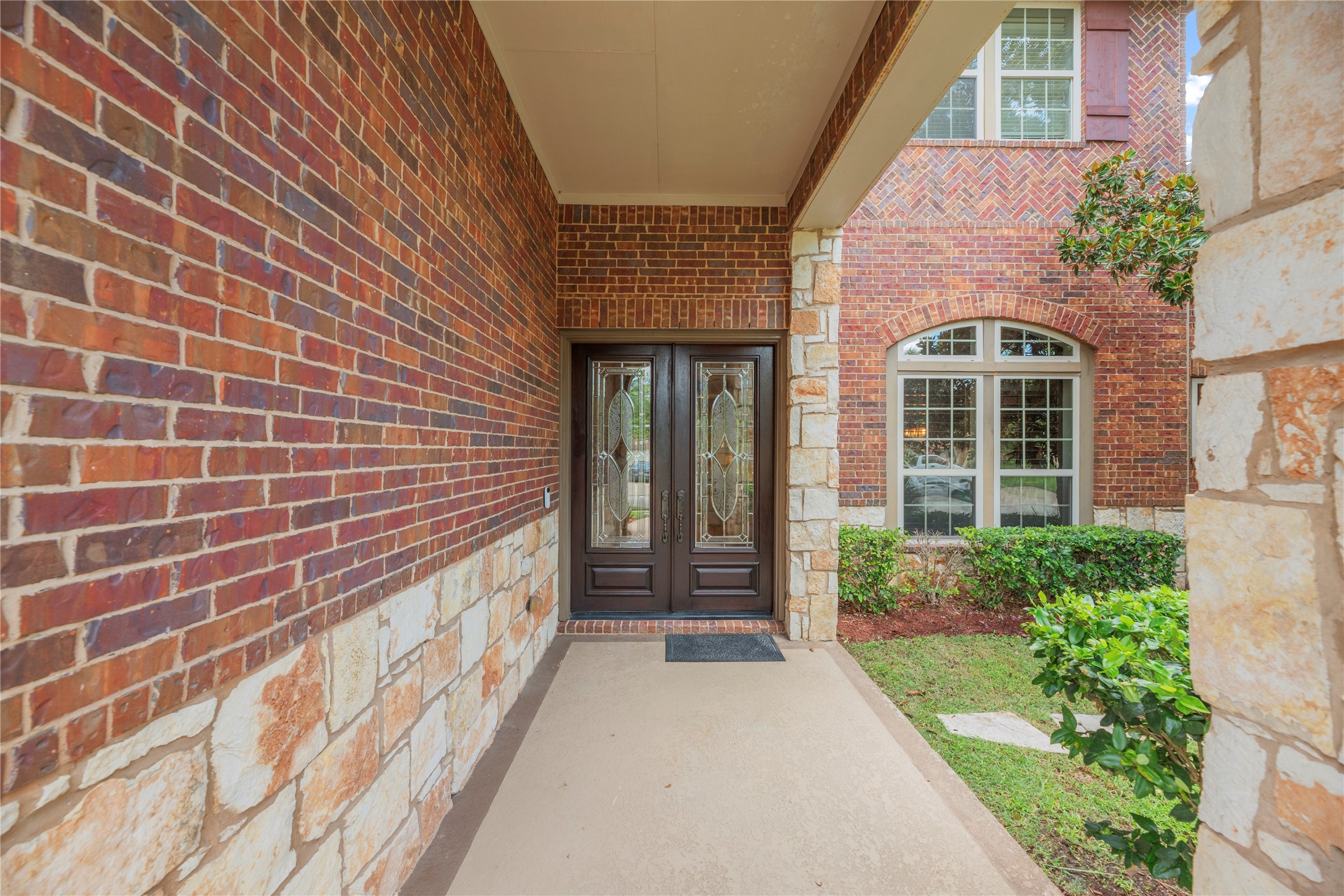 Front porch and entryway with lush landscaping.