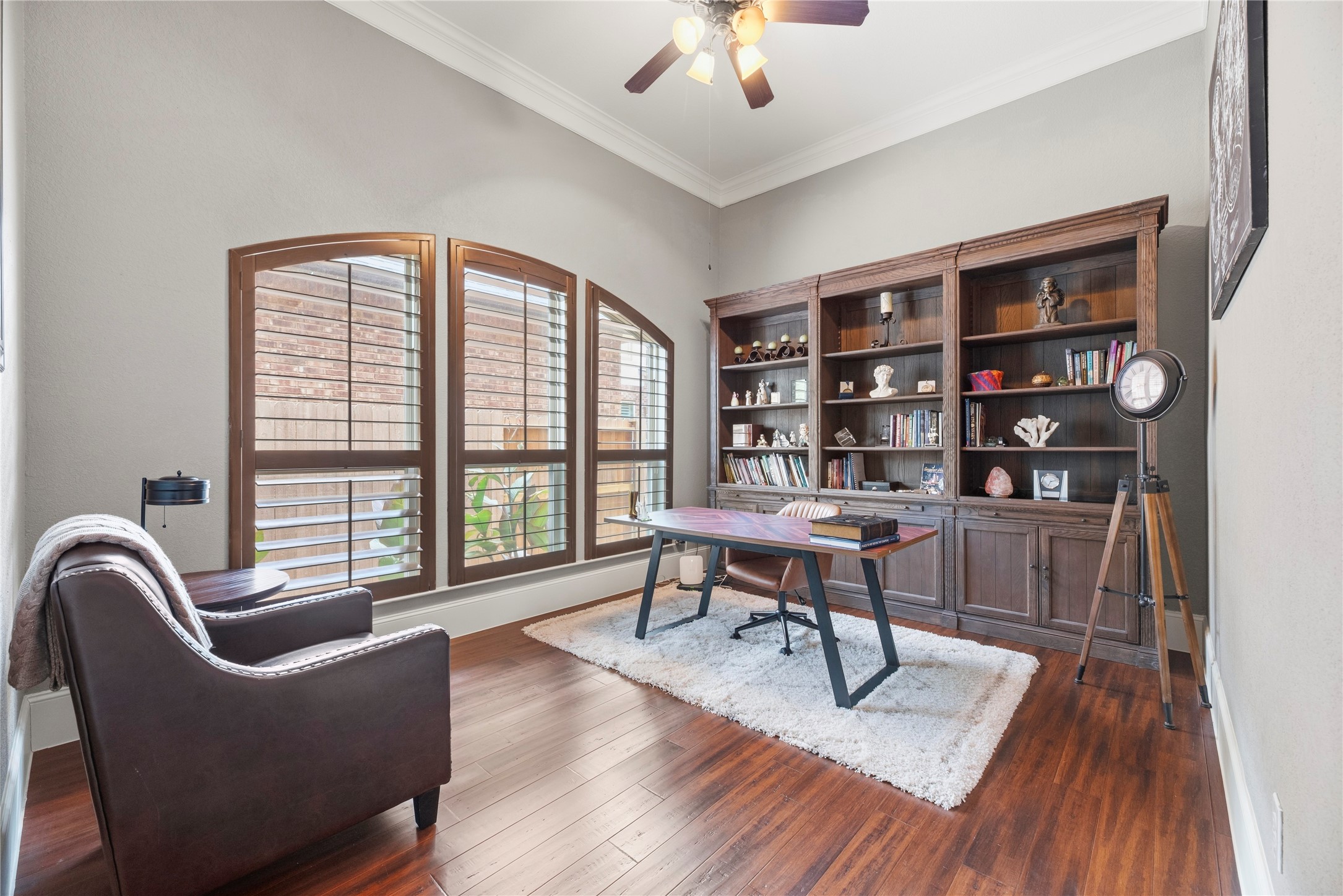 Beautiful home office complete with engineered wood floors, crown molding, and plantation shutters.